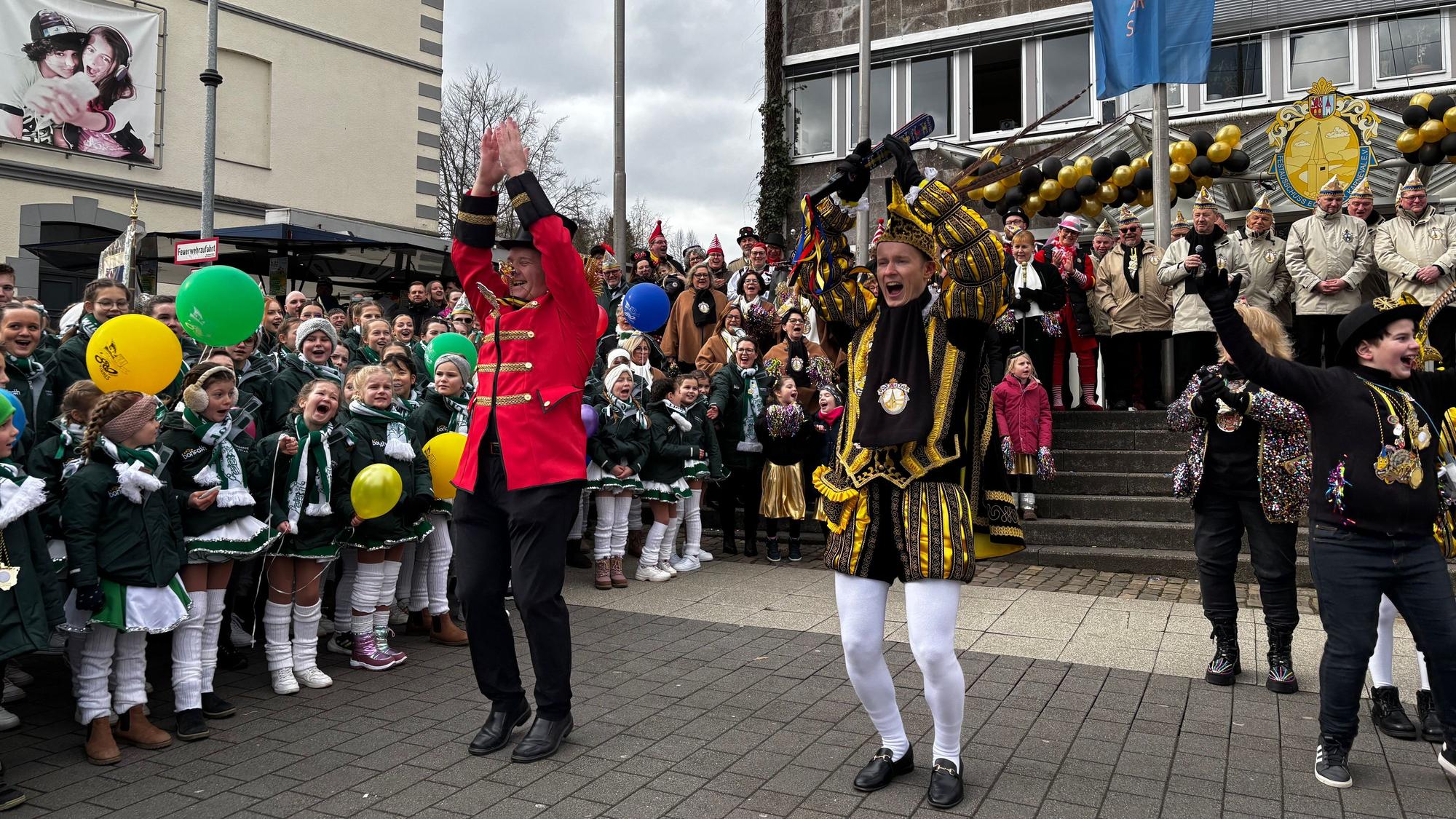 Zwei Männer springen in die Luft und schlagen gerade die Arme über dem Kopf zusammen.