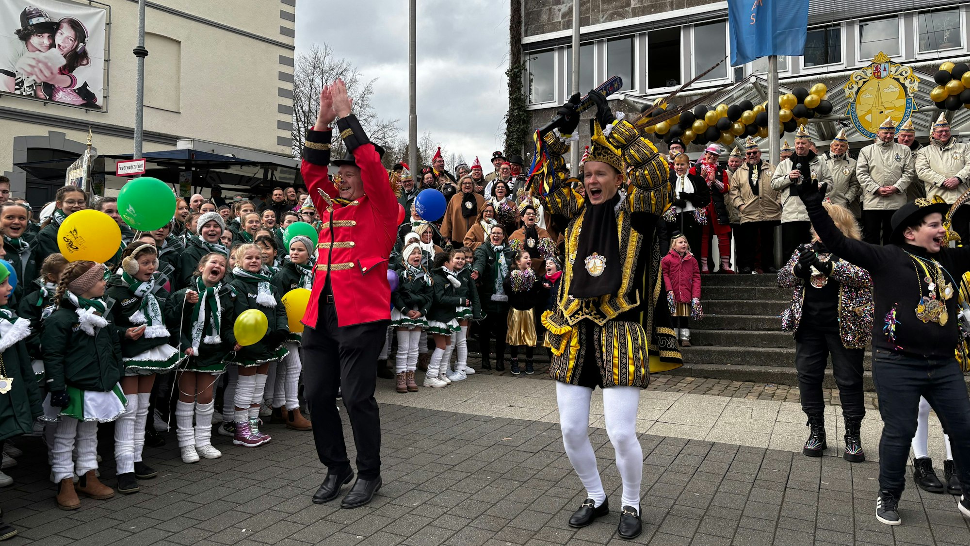 Zwei Männer springen in die Luft und schlagen gerade die Arme über dem Kopf zusammen.