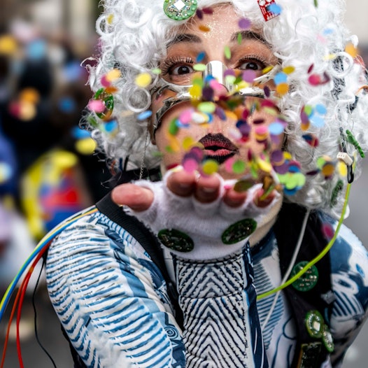 Eine Frau pustet Konfettis.