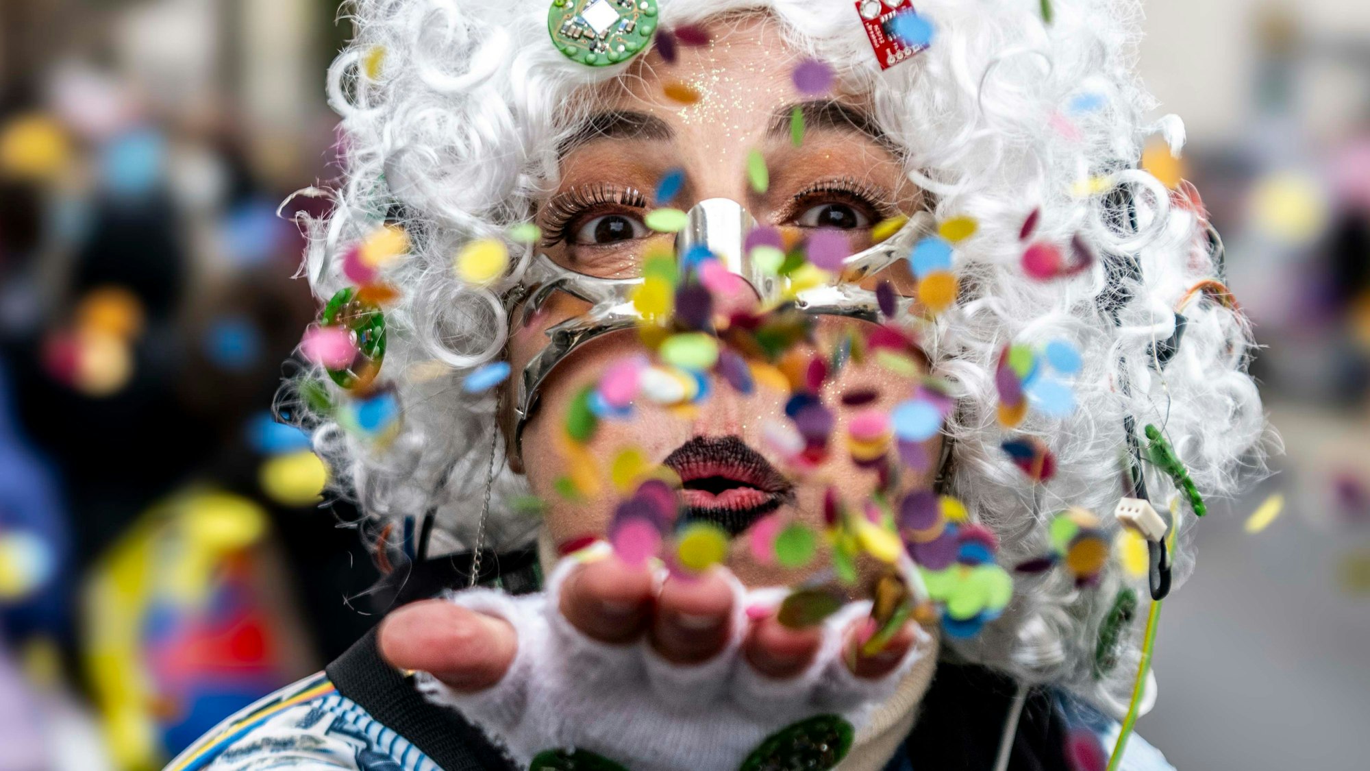Eine Frau pustet Konfettis.