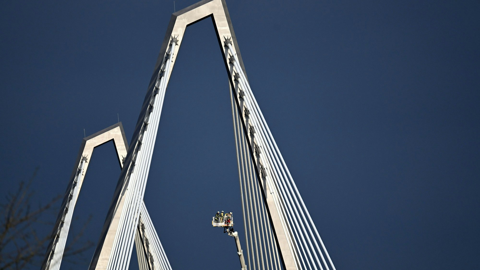 Mit einem Spezial-Hubwagen lassen sich Einsatzkräfte zu den Spitzdächern der Brückenpylone der Leverkusener Rheinbrücke hochfahren.