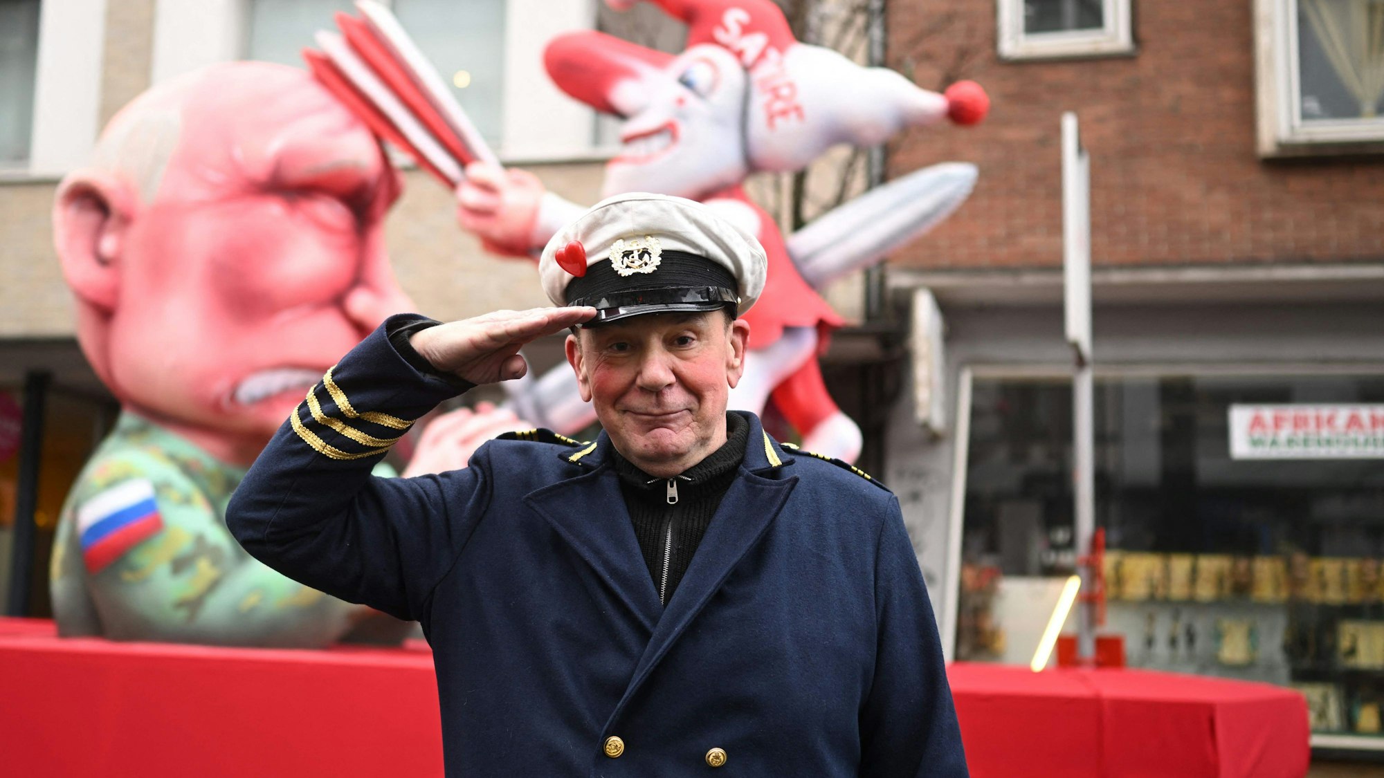 Der deutsche Karnevalswagenbauer Jacques Tilly posiert für Fotografen vor einer seiner Kreationen – einem Karnevalswagen mit dem russischen Präsidenten Wladimir Putin – während des Umzugs anlässlich des Rosenmontags am 16. Februar 2026 in Düsseldorf.