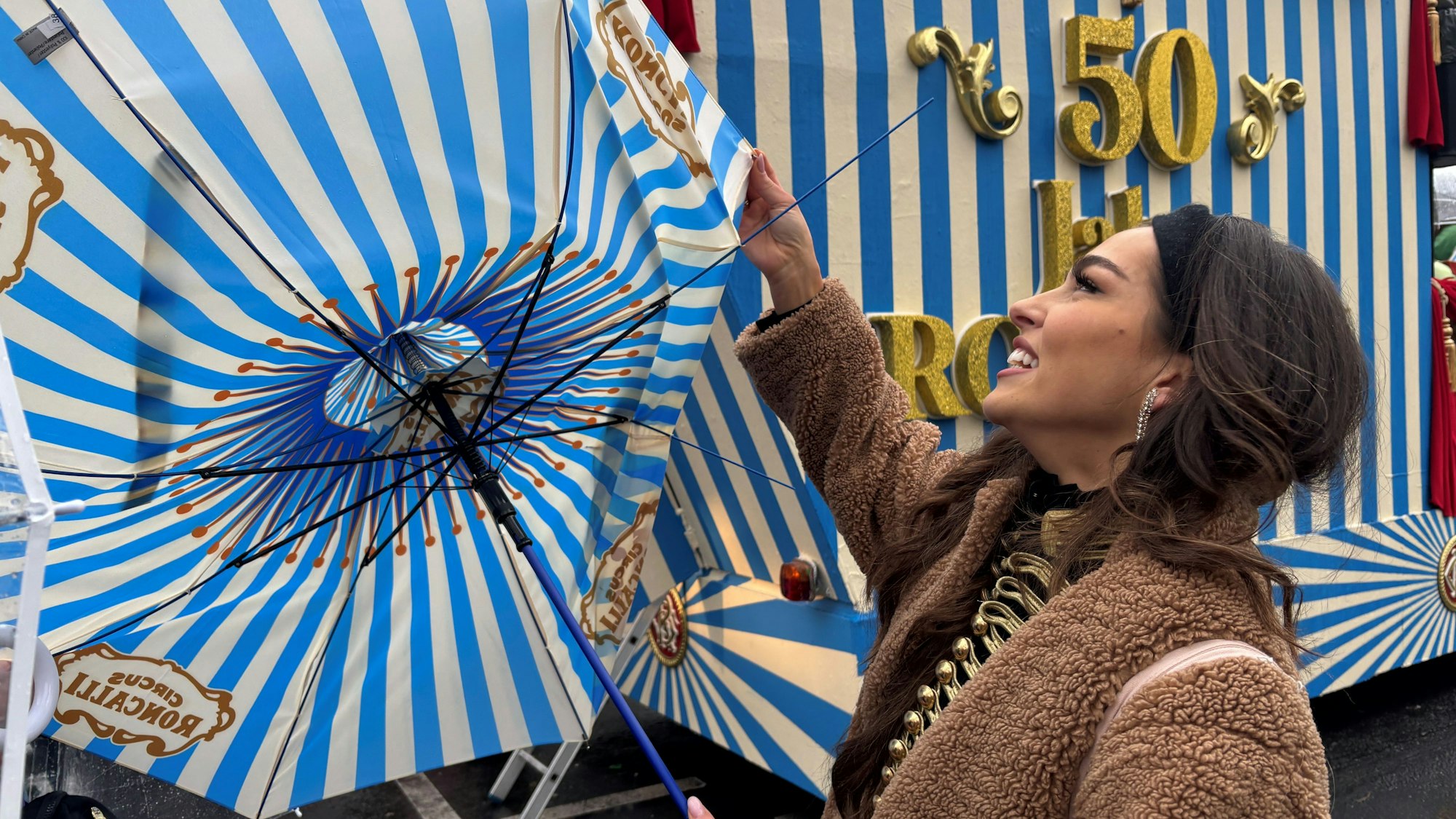 Artistin Lili Paul-Roncalli kämpft im Kölner Rosenmontagszug mit ihrem Regenschirm.