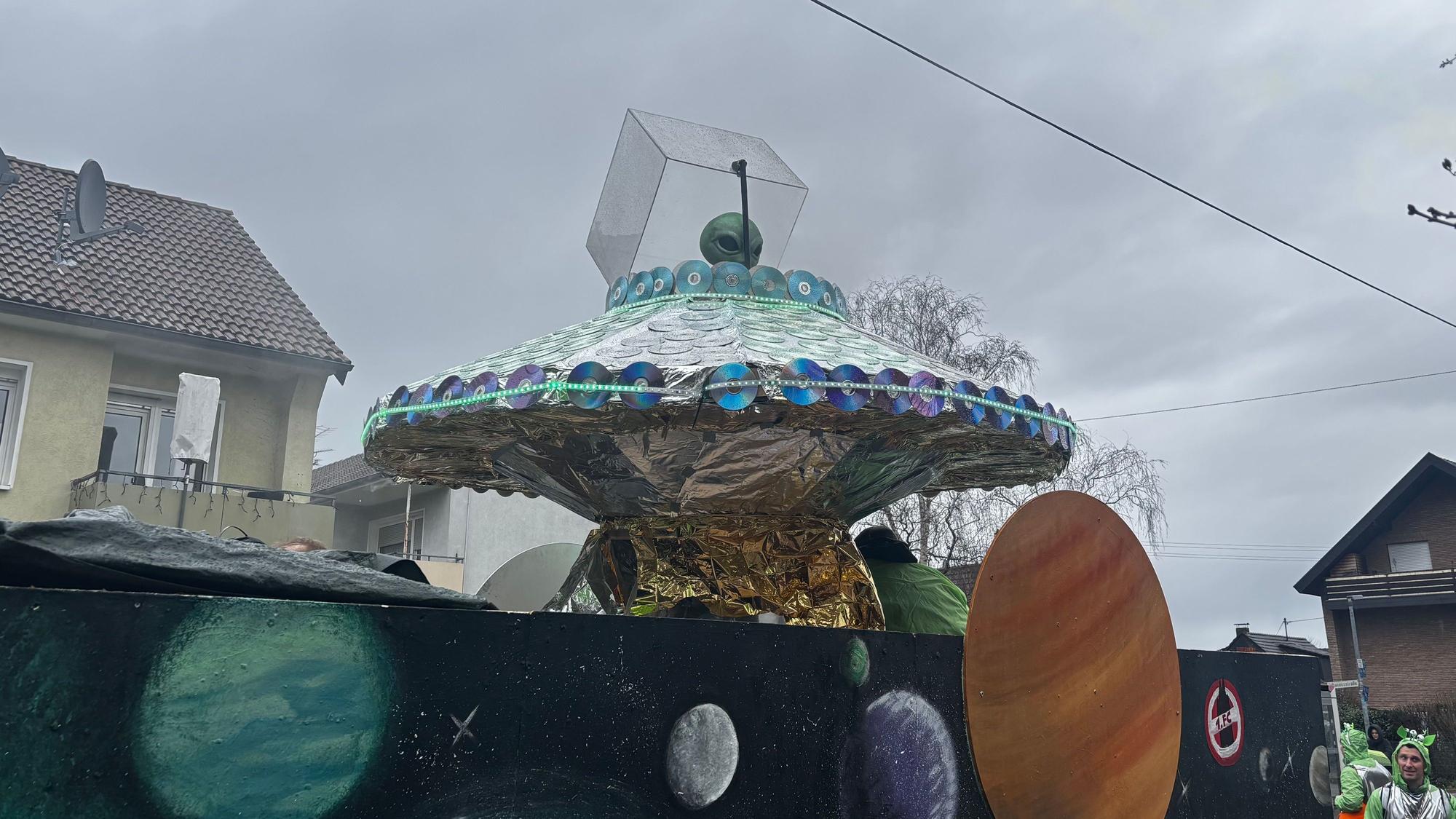 Blick auf das Ufo und das grüne Alien, welches aus der Luke schaut.