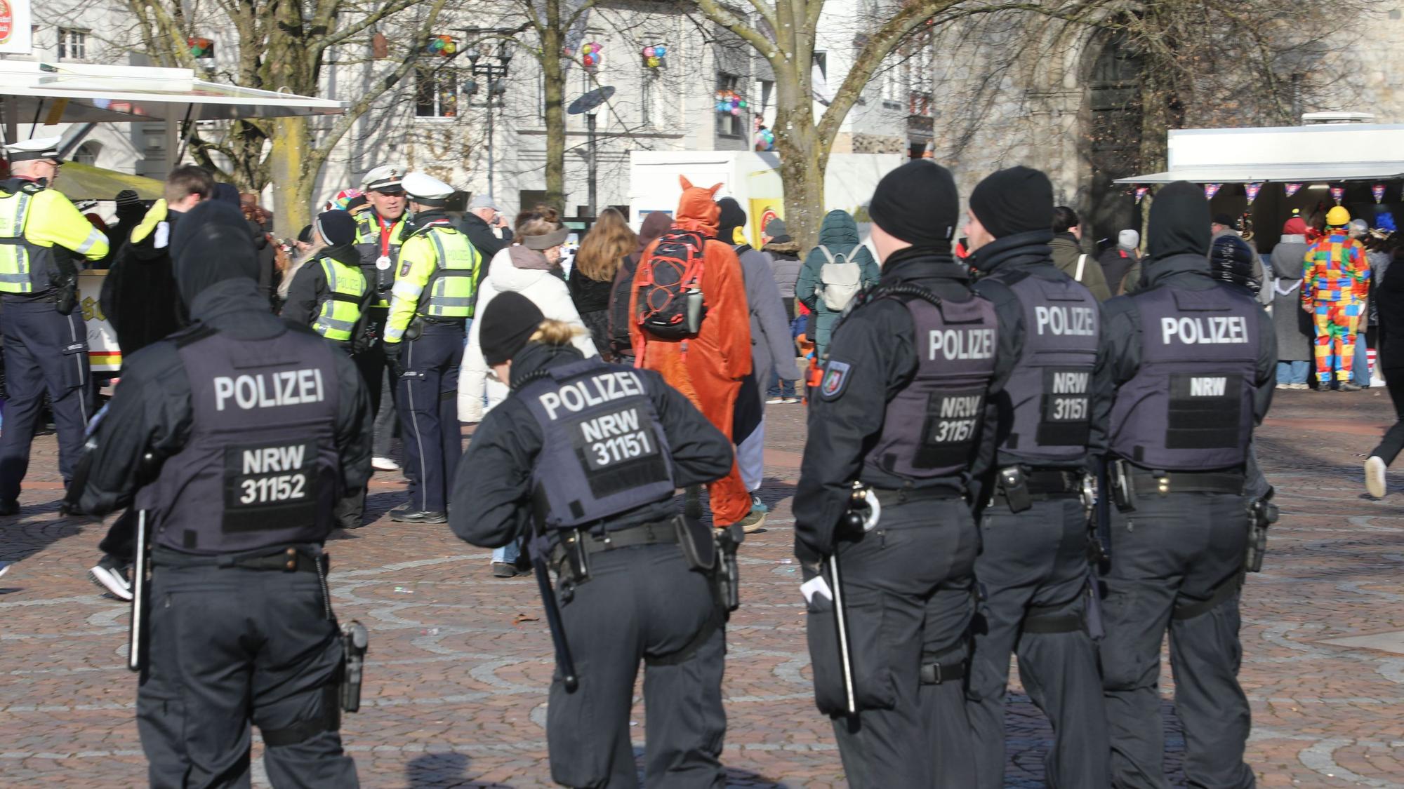 Mitglieder einer Einsatzhundertschaft der Polizei stehen am Karnevalszug Bergisch Gladbach auf dem Konrad-Adenauer-Platz.