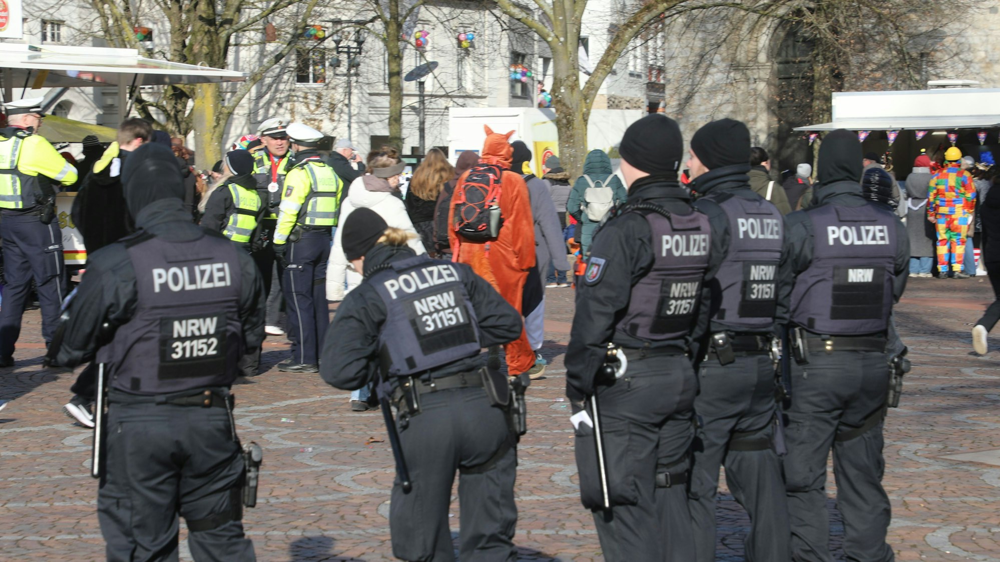 Mitglieder einer Einsatzhundertschaft der Polizei stehen am Karnevalszug Bergisch Gladbach auf dem Konrad-Adenauer-Platz.