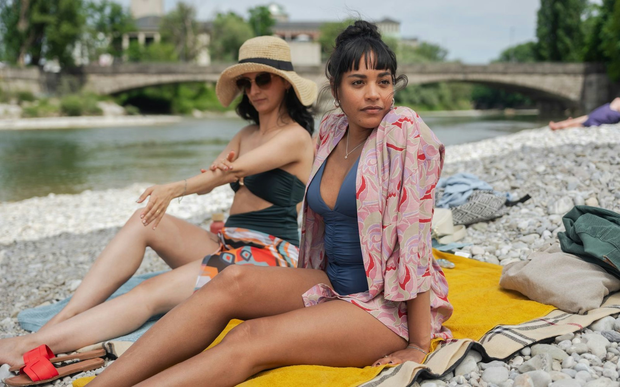Neben einem klugen Blick auf unsere Gesellschaft bietet „Damen“ auch traumhafte Aufnahmen aus dem Sommer in München: Sema (Şafak Şengül, links) und Maya (Salka Weber) sonnen sich wie viele an der Isar. (Bild: BR/Kineo Film GmbH/Lars Nitsch)