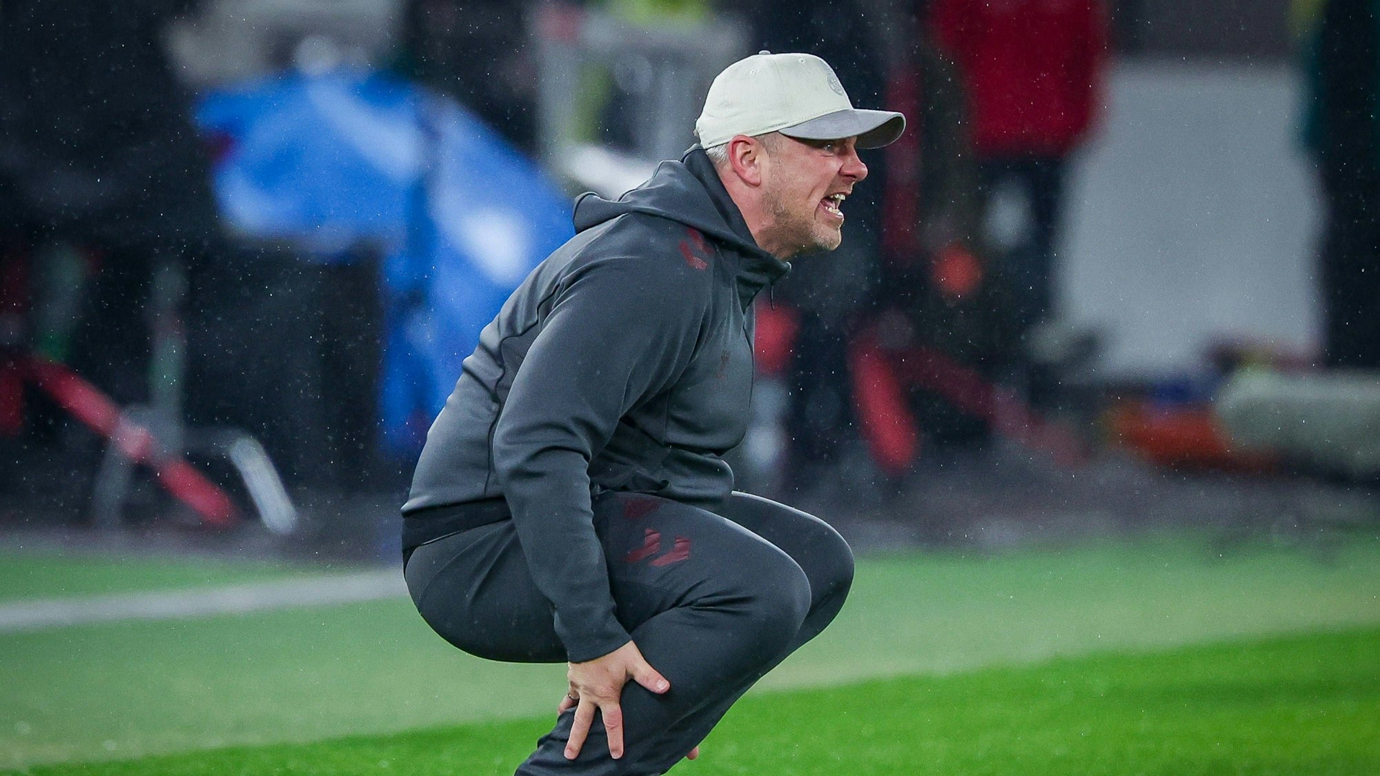 Lukas Kwasniok hockt am Seitenrand und ruft etwas.