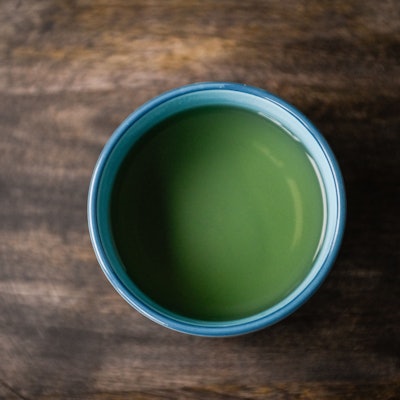 Eine Tasse Kräutertee steht auf einem Tisch.