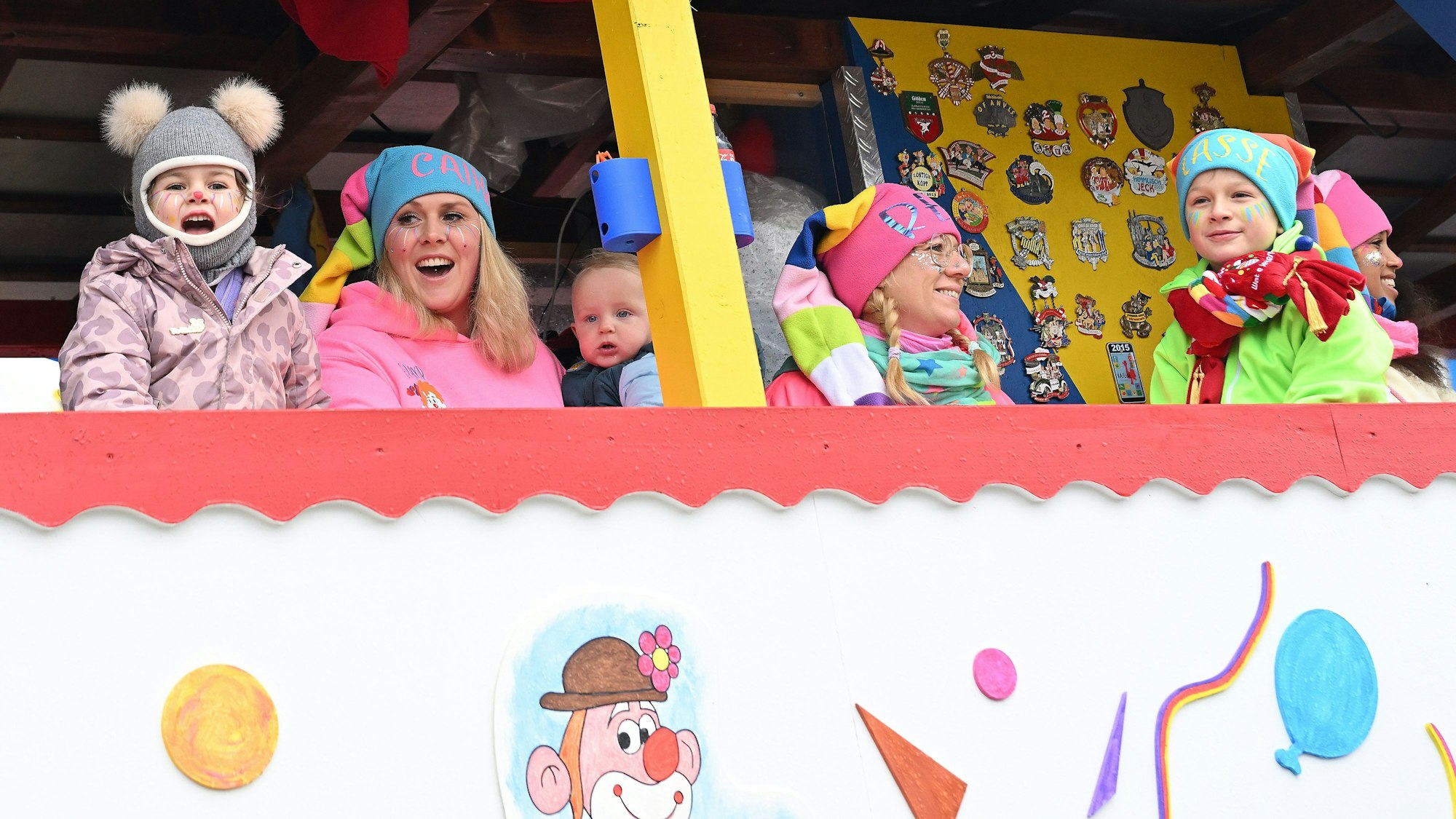 Clowns schauen von einem Wagen herab.