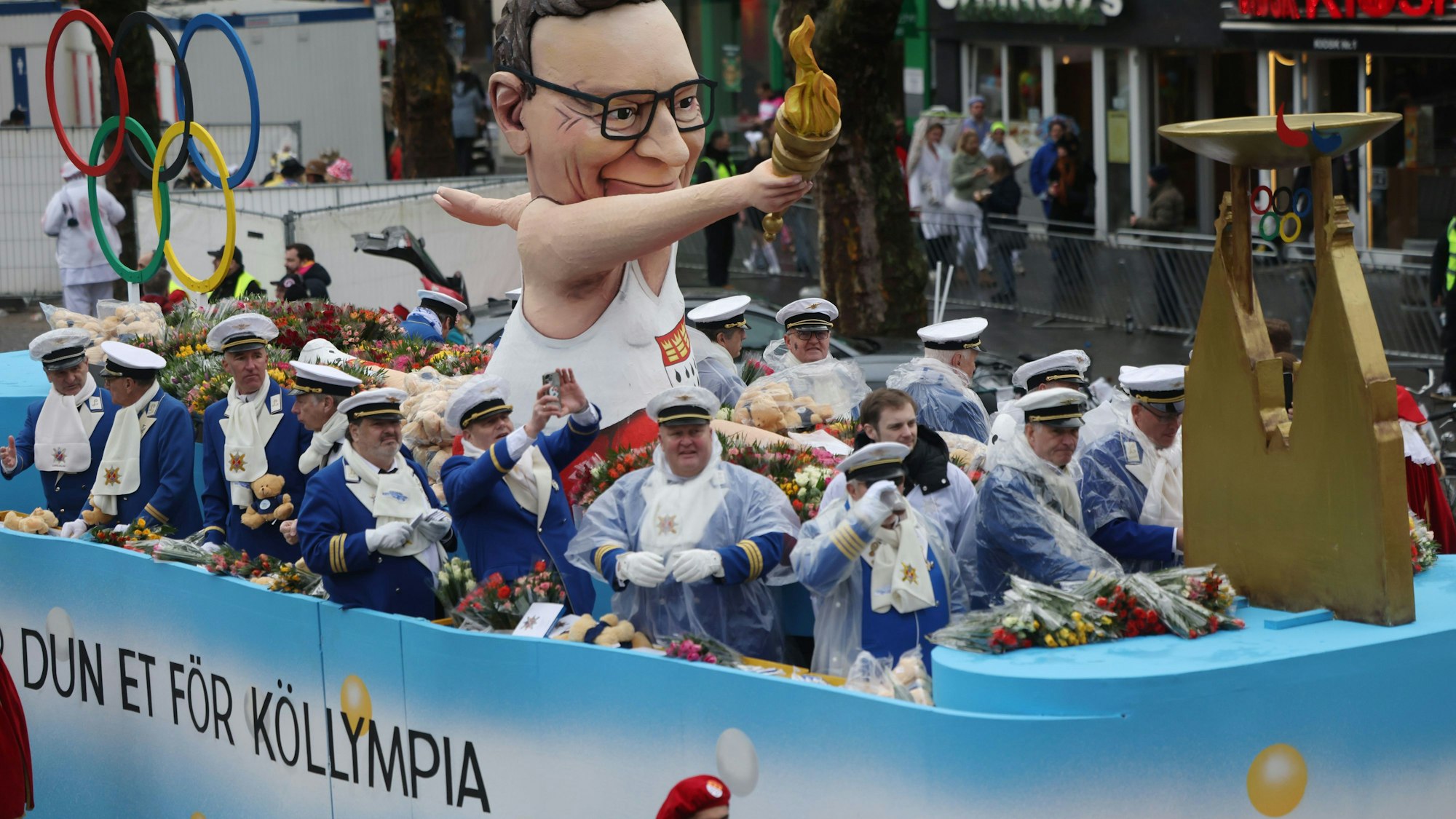 Bei ihm läuft's: Ein Motivwagen mit dem Oberbürgermeister samt Olympischem Feuer nimmt am Rosenmontagszug in Köln teil.
