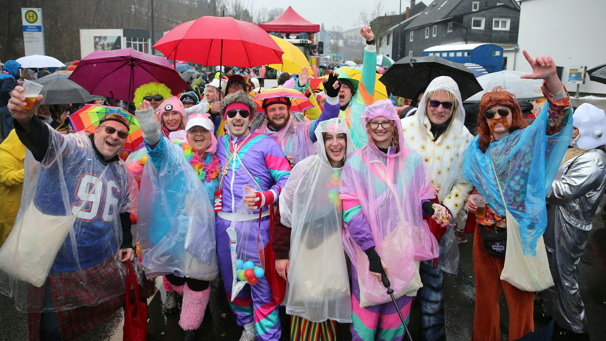 Eine kostümierte Gruppe mit Regenschirmen.