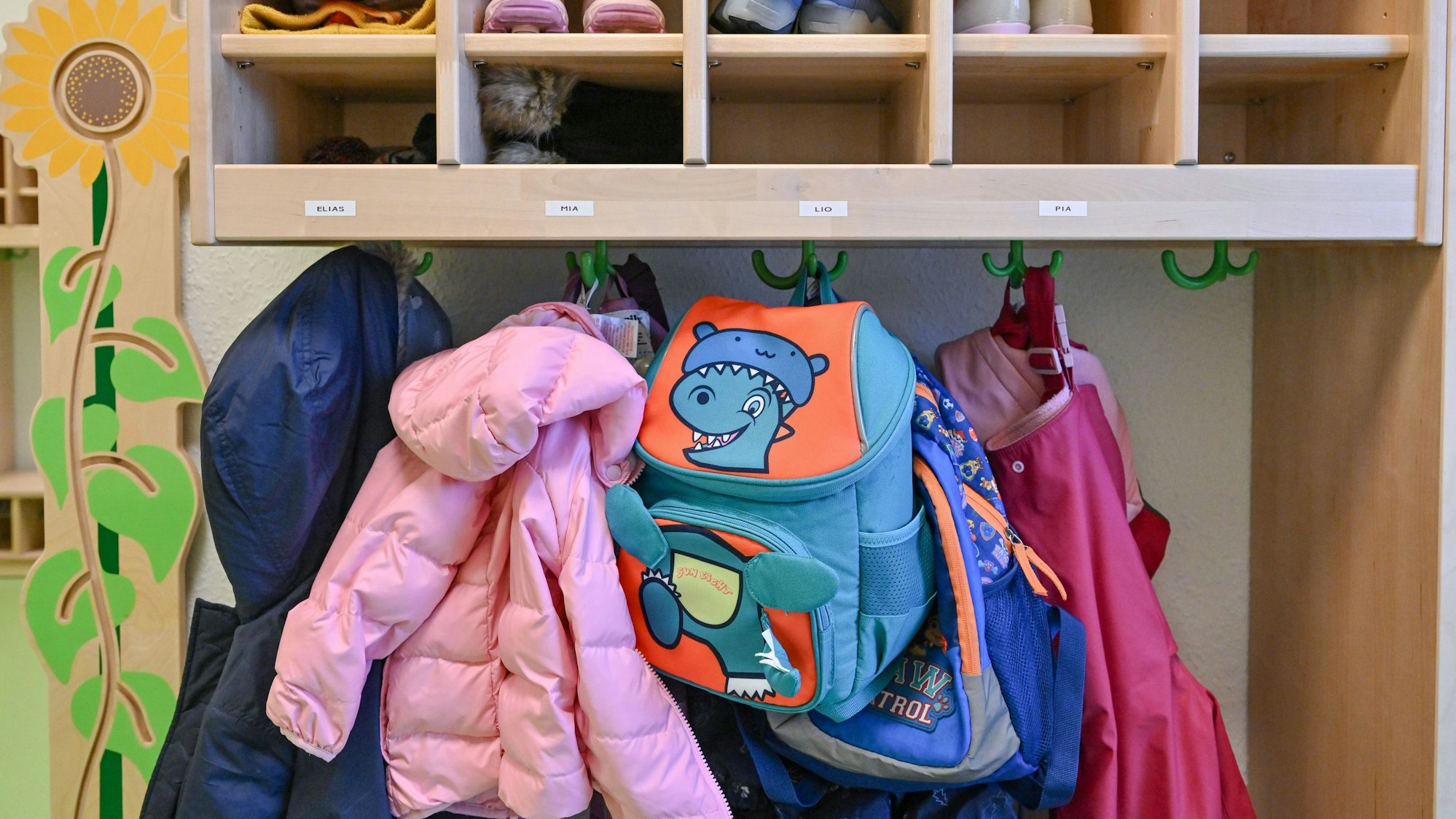 Kleidung von Kindern hängt in einer Kita.