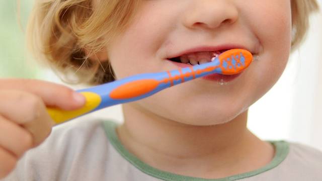 ILLUSTRATION - Schutz vor Karies: Kinderzahnpasten mit Fluorid härten den Zahnschmelz und beugen Schäden vor. (zu dpa: «Test: Jeder dritten Kinderzahnpasta fehlt Fluorid») Foto: Andreas Gebert/dpa/dpa-tmn - Honorarfrei nur für Bezieher des dpa-Themendienstes +++ dpa-Themendienst +++