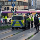 Polizisten stehen an einer Unfallstelle. Beim Karnevalsumzug in Mönchengladbach ist eine Frau unter einen Bus geraten und verletzt worden.