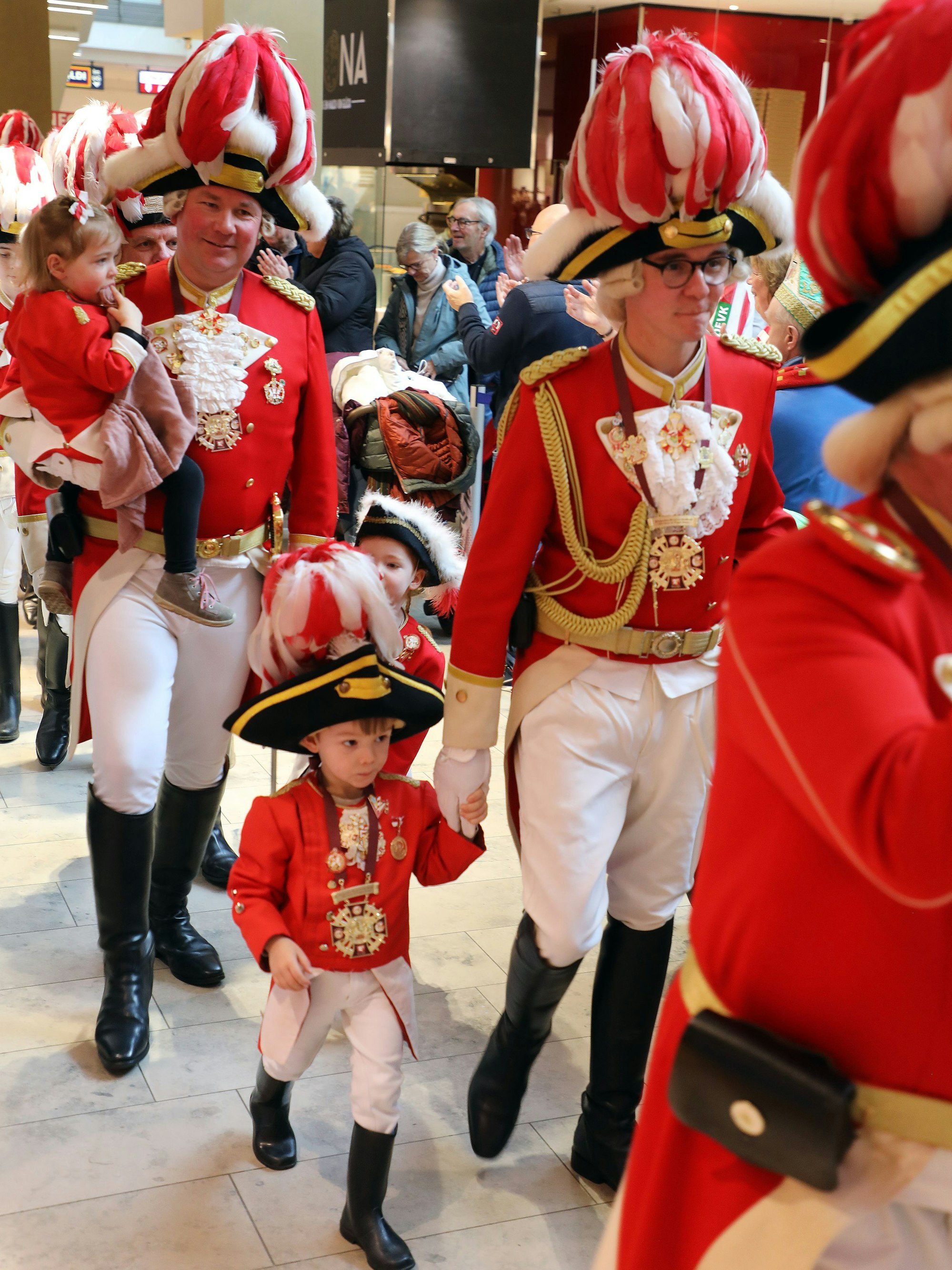Prinzengarde-Geschäftsführer Philip Wallraf (l.) und Kommandant Marco Wasserberg mit Nachwuchs auf dem Weg zur Bühne beim karnevalistischen Biwak.