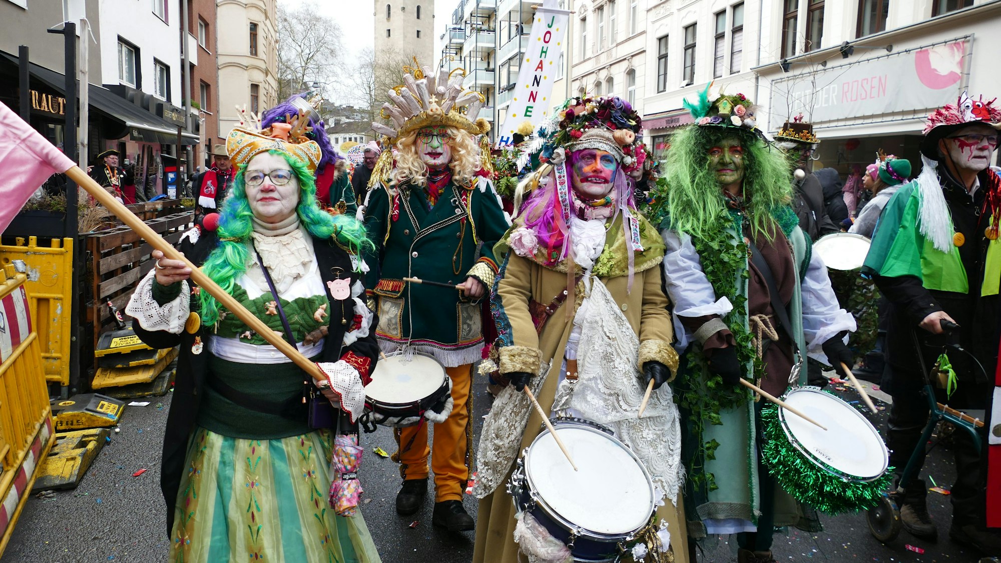 Eine Gruppe Trommler zieht eine Straße entlang.
