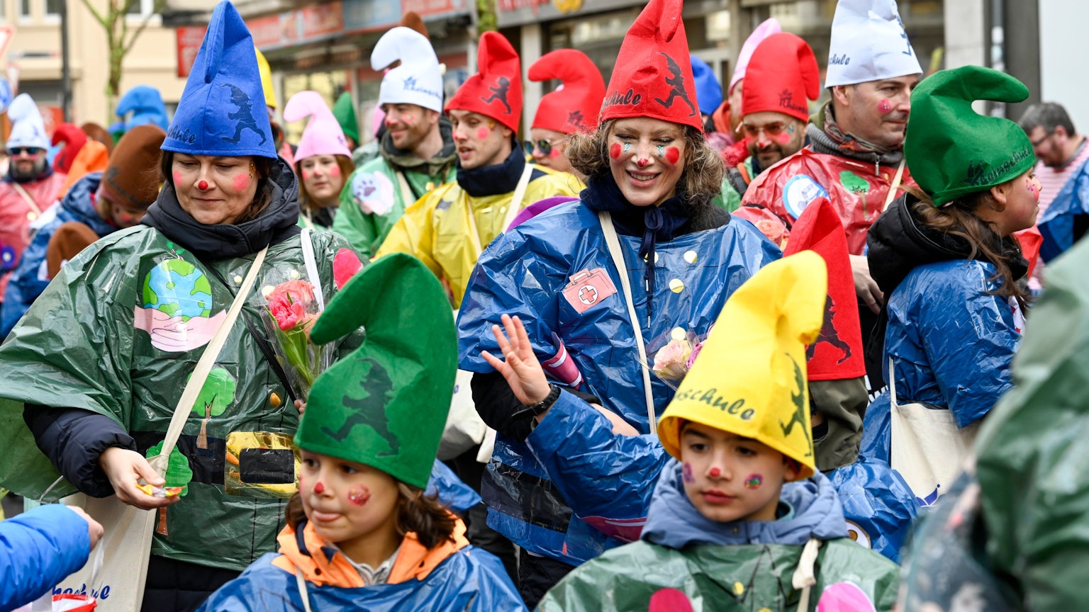 Eine Gruppe Kinder und Erwachsene ist mit Zipfelmützen unterwegs.