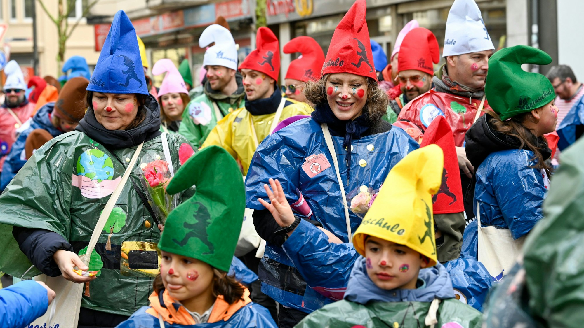 Eine Gruppe Kinder und Erwachsene ist mit Zipfelmützen unterwegs.