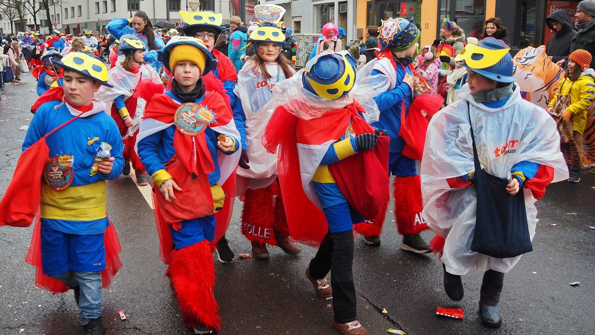 Schüler in blau-roten Kostümen laufen im Zug mit.