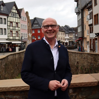 Sebastian Glatzel steht auf einer Brücke, die über die Erft führt. Im Hintergrund sieht man Bad Münstereifel.