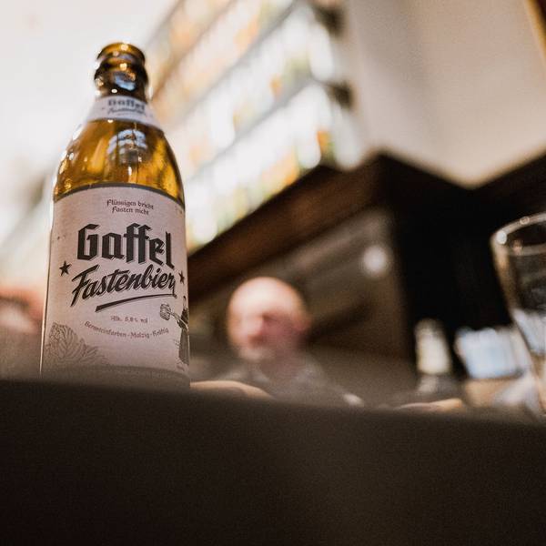 Eine Flasche Bier steht in einem Brauhaus auf einem Tisch.