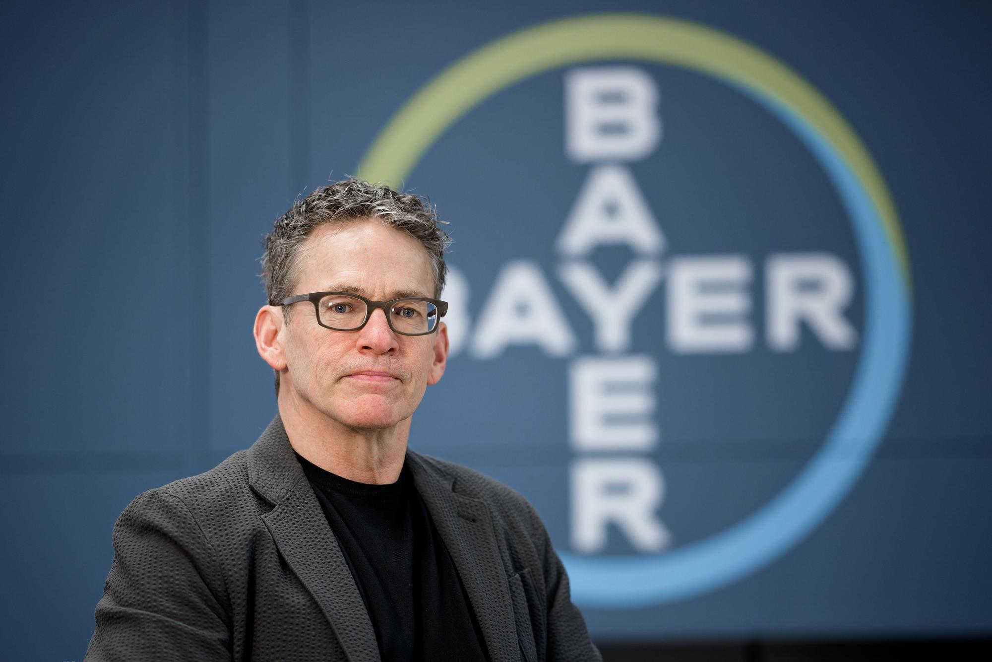 Bill Anderson, Vorstandsvorsitzender der Bayer AG, in der Zentrale des Unternehmens. Im Hintergrund das Bayer-Kreuz.