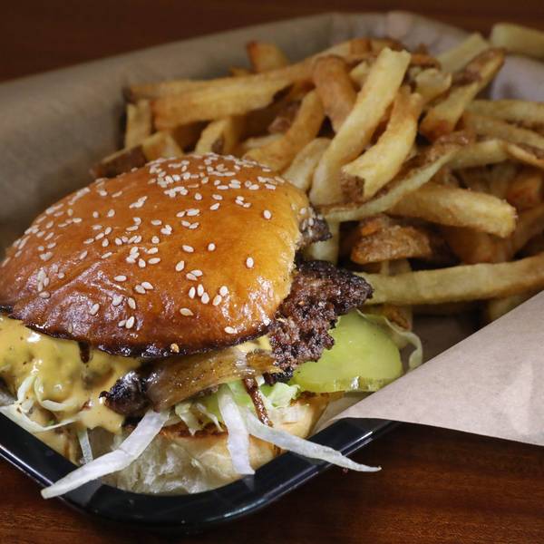 Smash Burger mit Pommes im Körbchen. (Symbolbild)