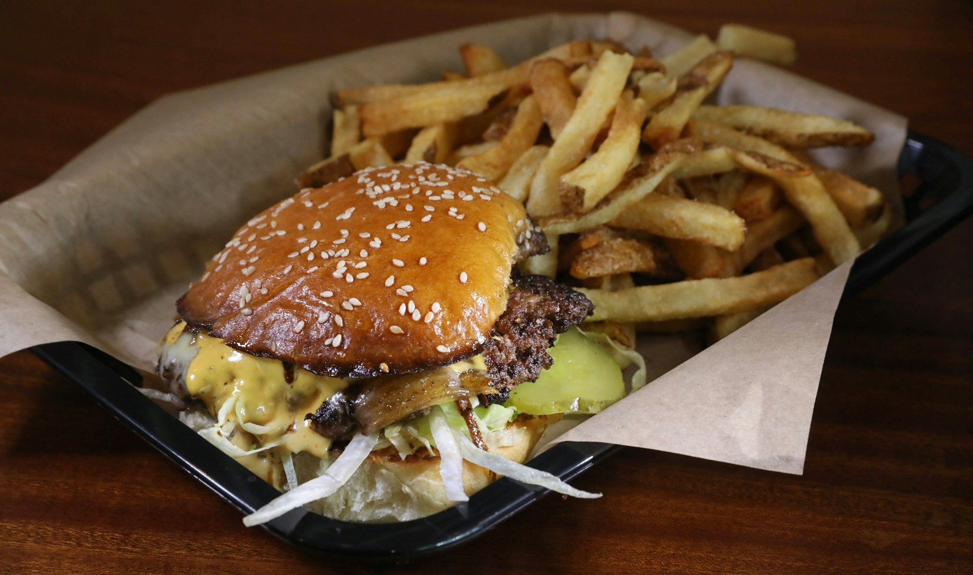 Smash Burger mit Pommes im Körbchen. (Symbolbild)