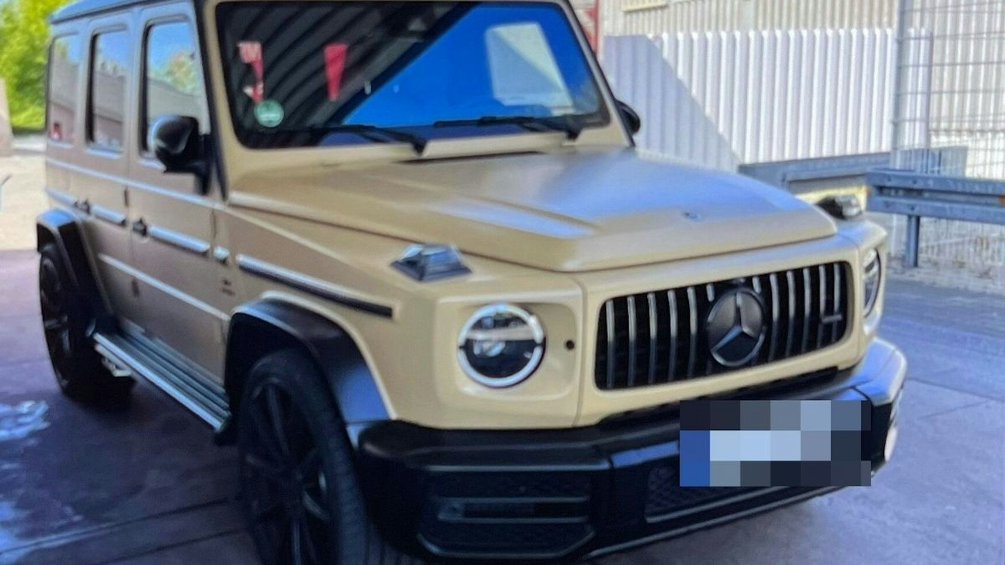 Symbolbild: Ein sandgelber Mercedes-AMG steht auf einer Straße.