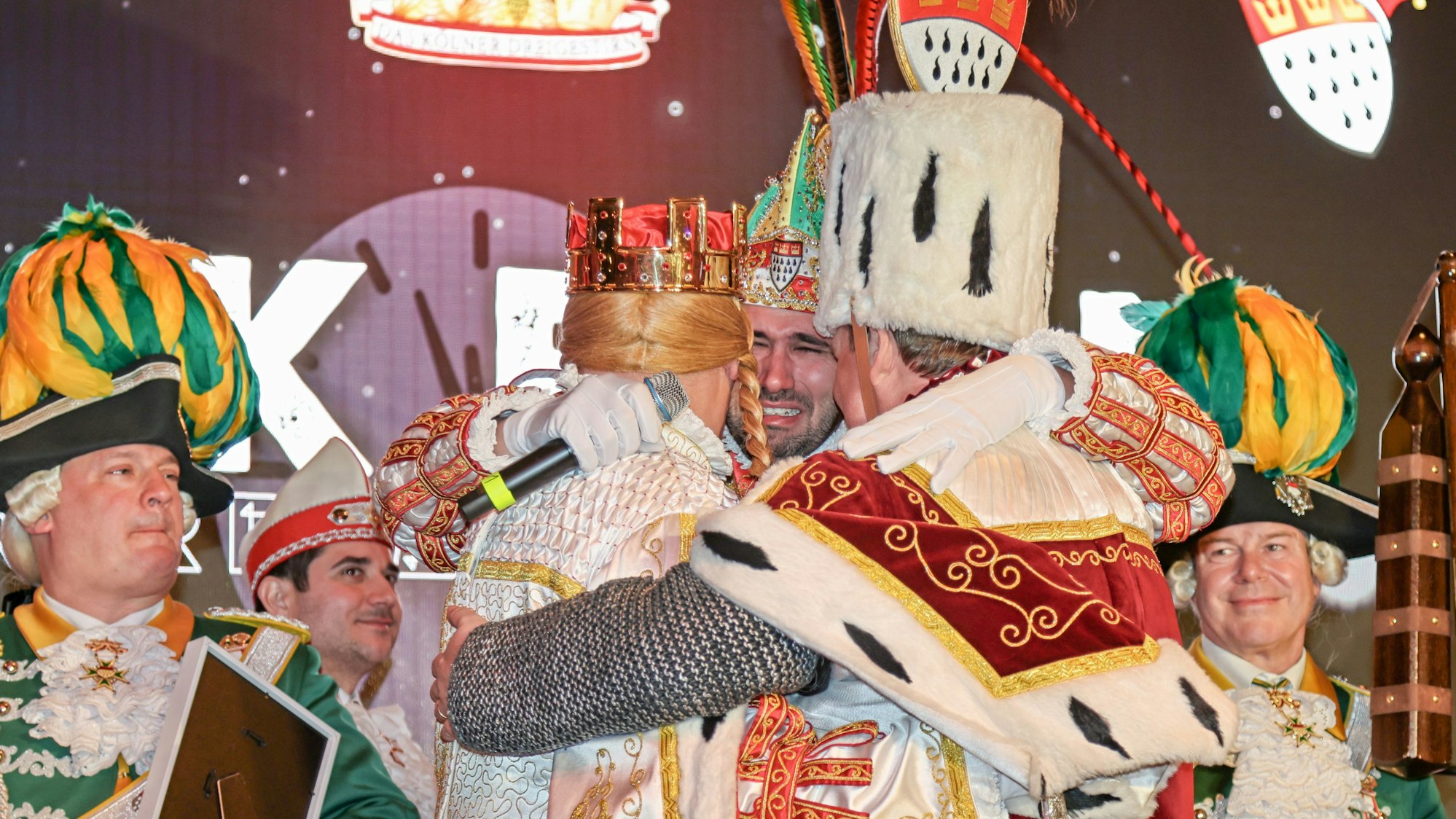 Das Dreigestirn liegt sich weinend in den Armen.