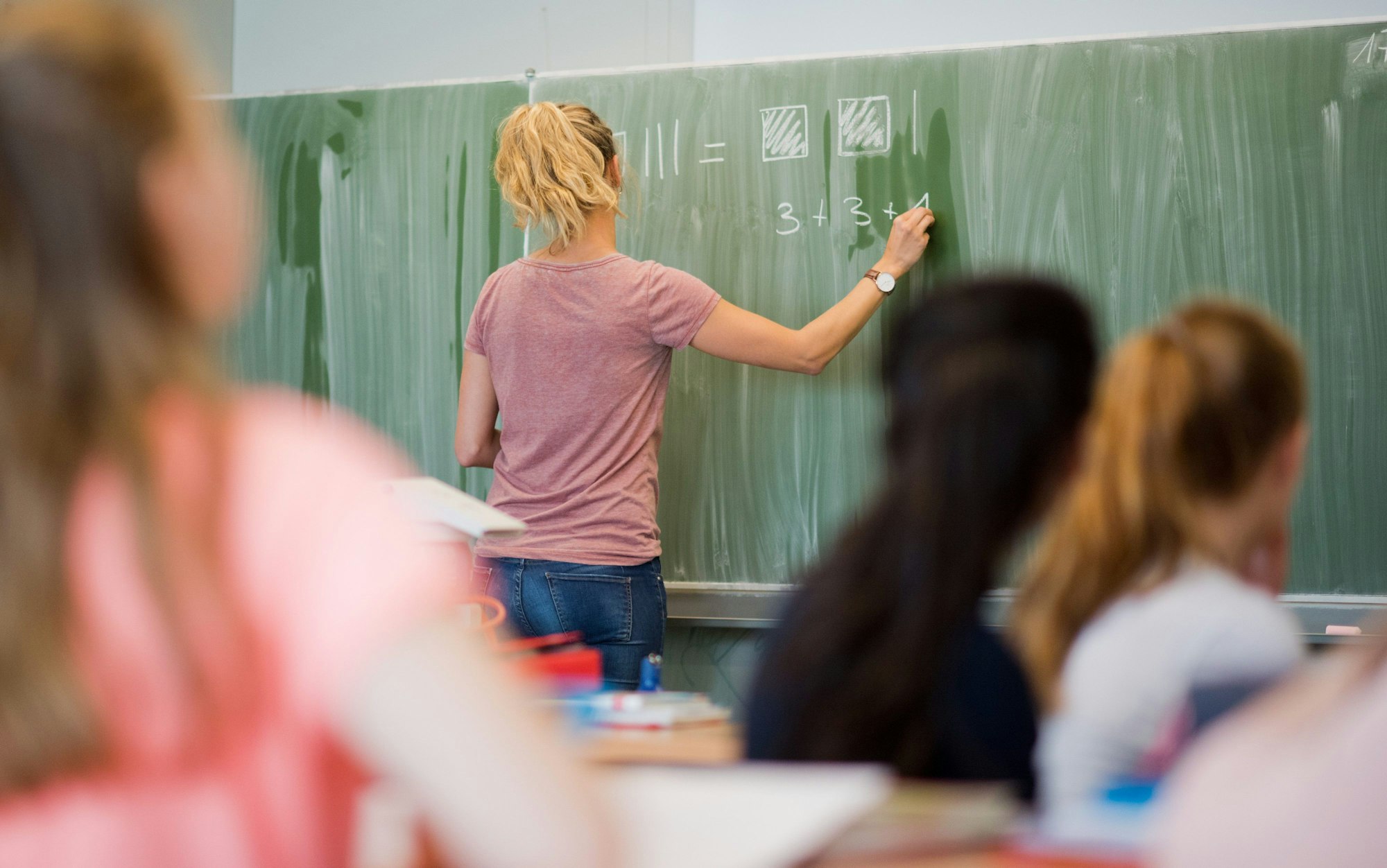 Eine Lehrerin schreibt im Mathematikunterricht einer achten Klasse an einer Integrierten Gesamtschule in Hannover an eine Schultafel.