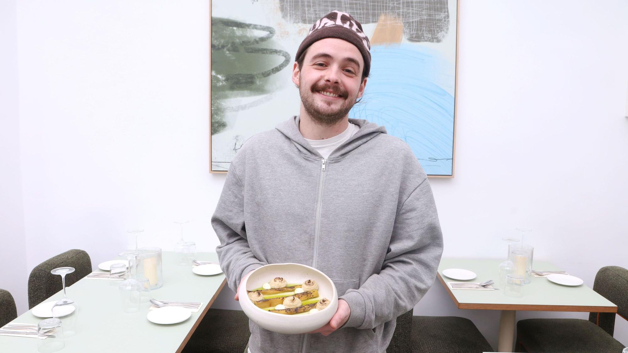 18.02.2026, Köln: Gastrokolumne „Schmeckts Frau Floss?“ im ONDA. Sascha Bobb mit dem Tellergericht verbrannter Lauch Foto: Arton Krasniqi