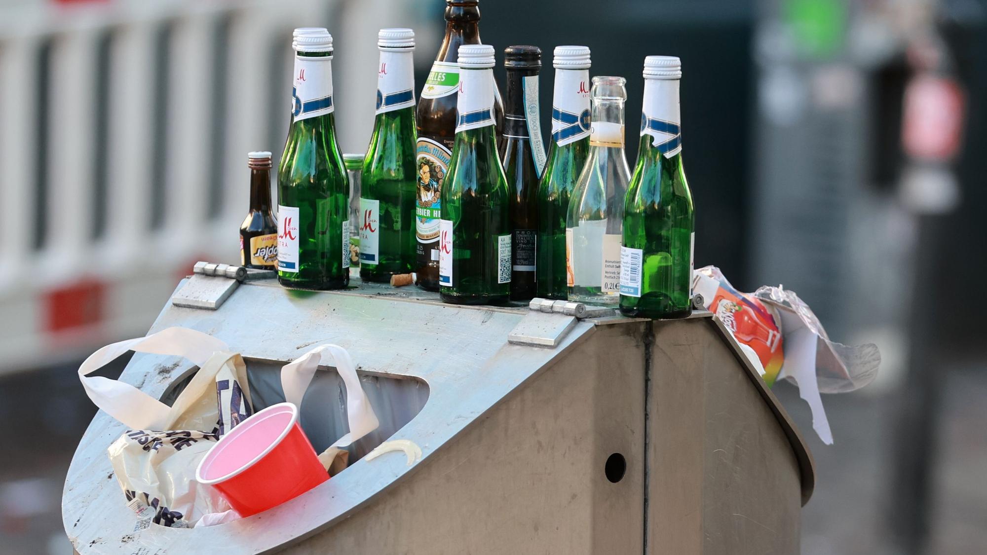 leere Sektflaschen auf einem Mülleimer