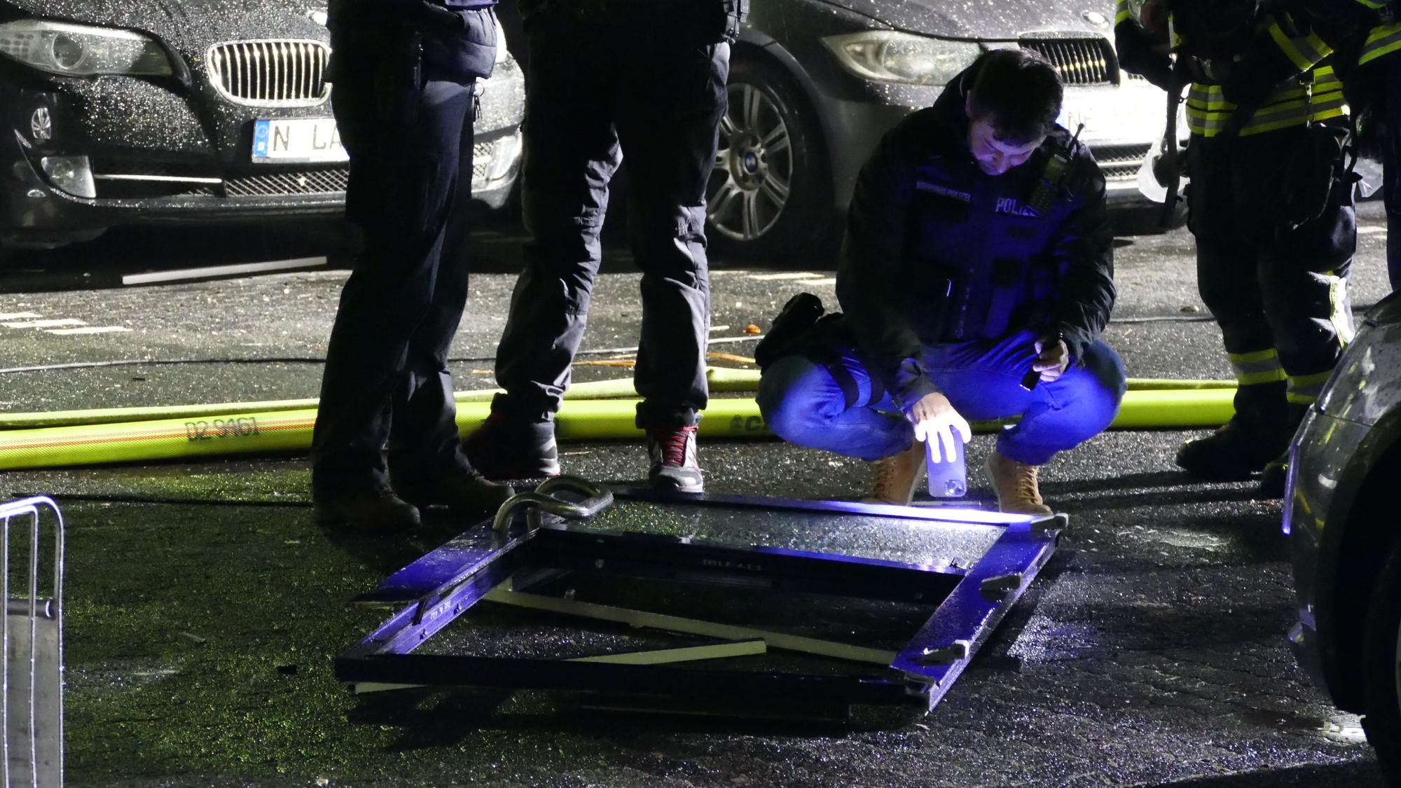 Ein Polizist untersucht die Eingangstür, die rund zehn Meter weit vor dem Gebäude lag.