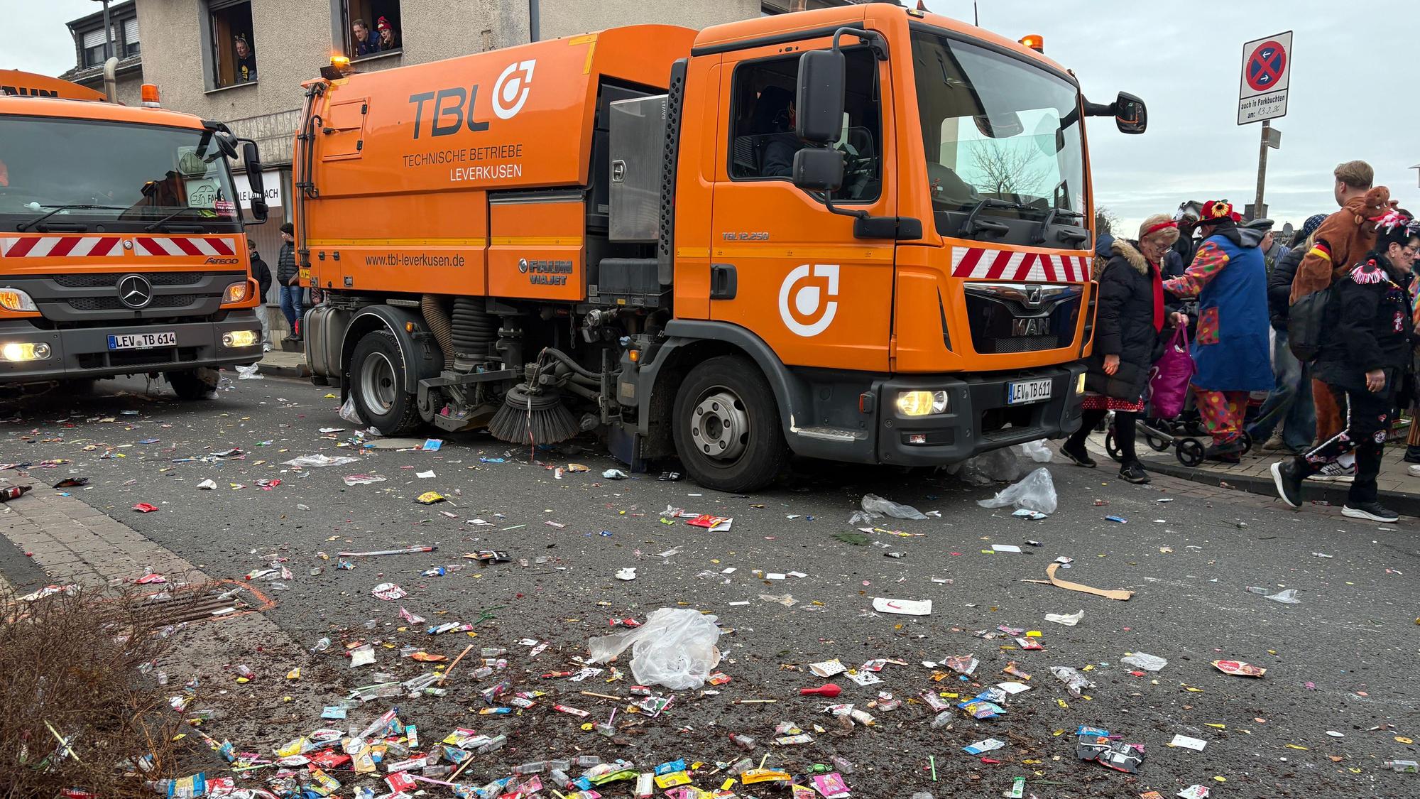 Mitarbeiter der TBL säubern nach dem Karnevalszug die Straße.