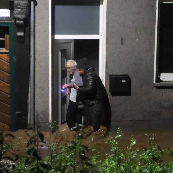 Ein junger Mann hilft einem alten Mann aus dem Haus. Aufnahme aus der Flutnacht 14./15. Juli 2021.