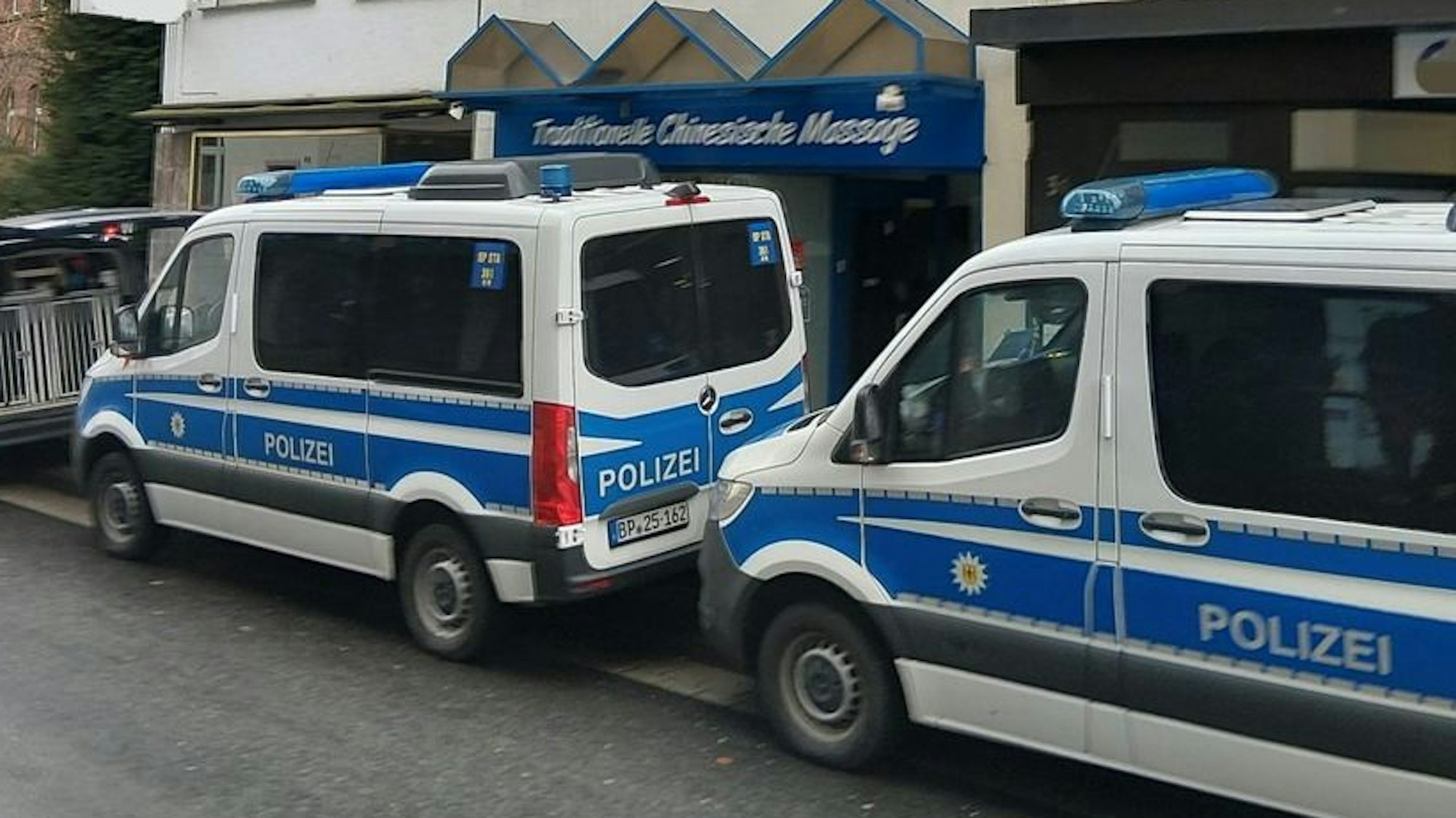 Das Bild zeigt Polizeifahrzeug vor einem Massagestudio in Brühl.