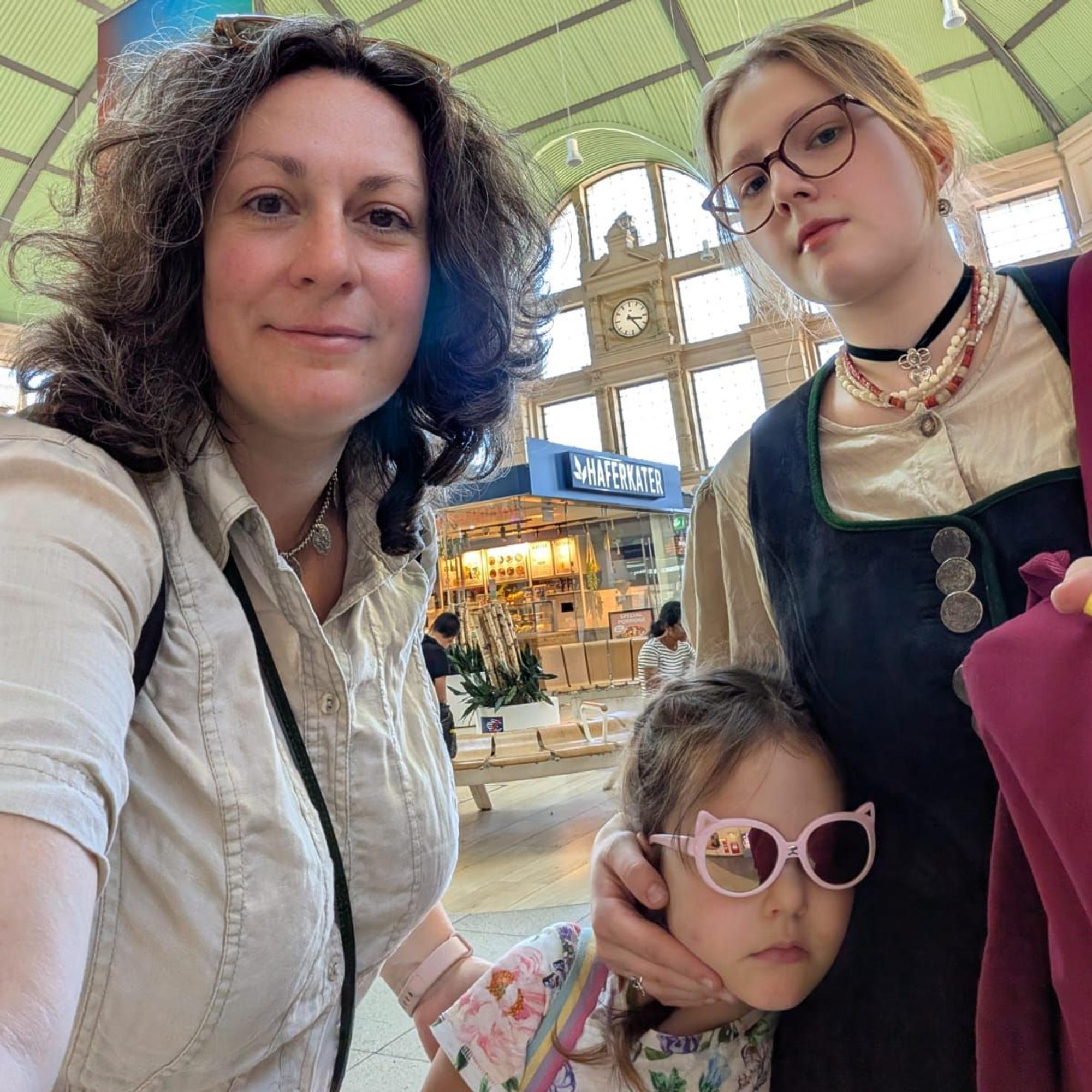 Bild von Mutter und zwei Töchtern, im Hintergrund eine Shoppingmall