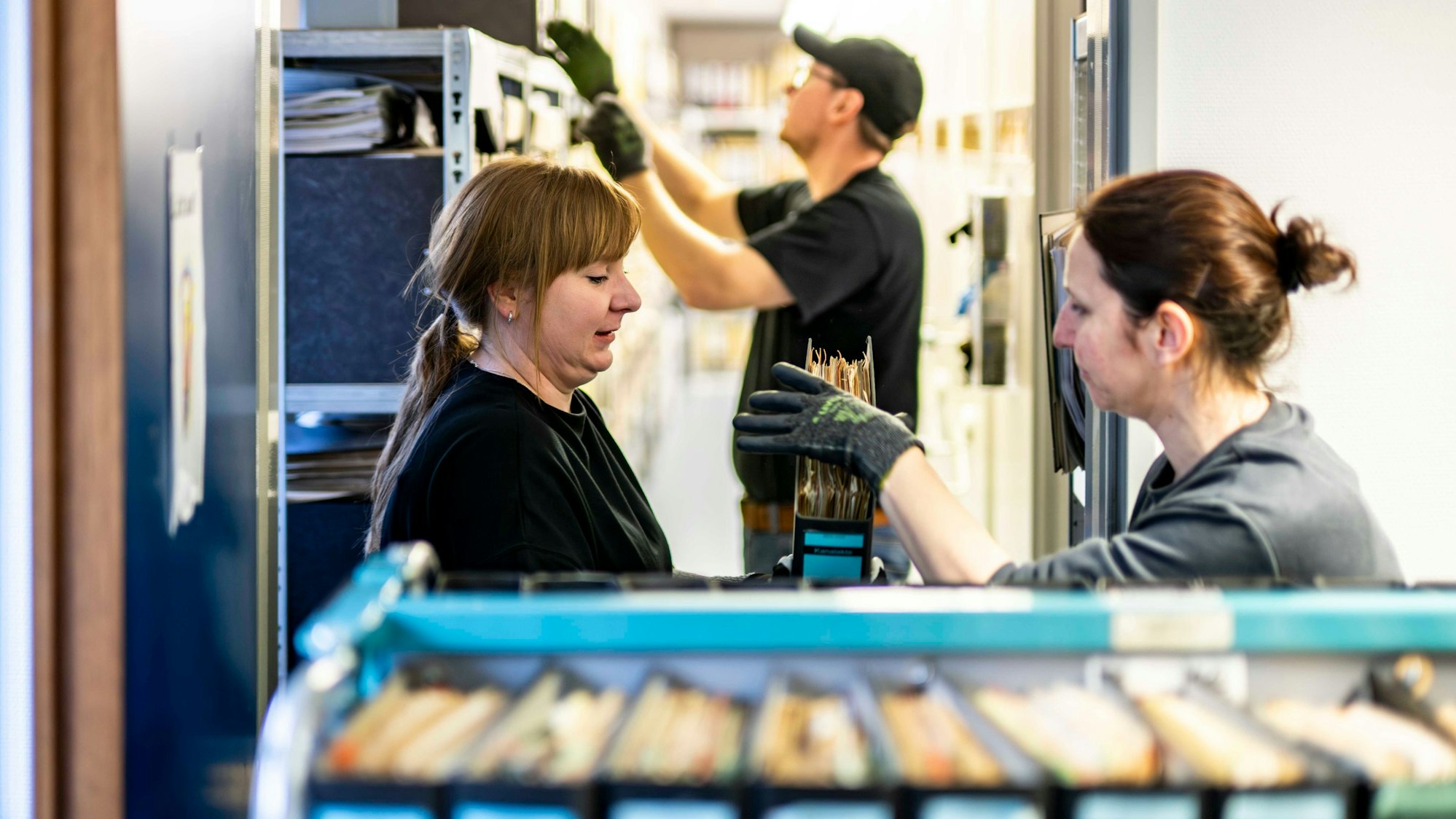 Das Bild zeigt das Team des Euskirchener Stadtarchivs beim Verladen von Aktenordnern.