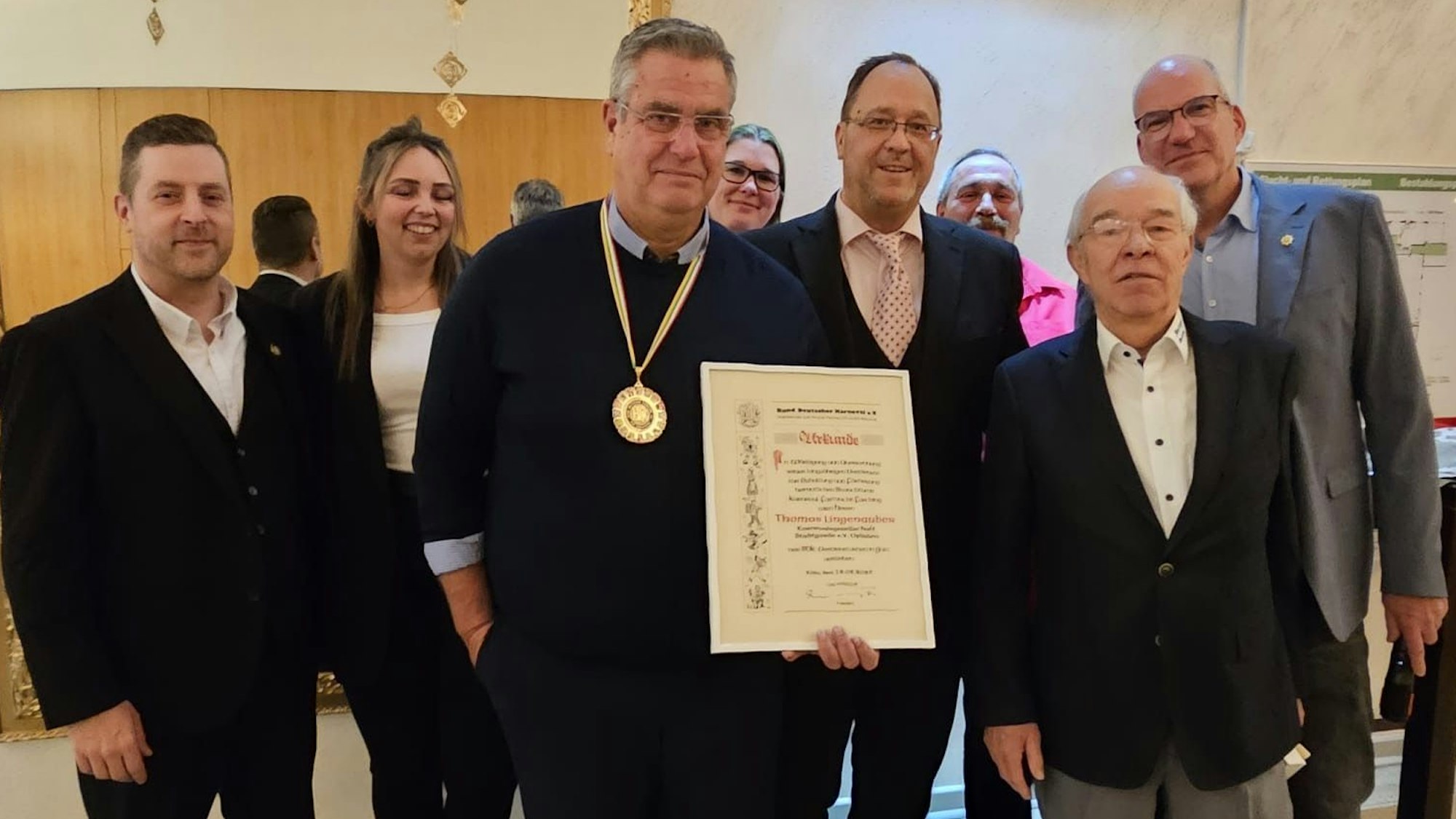 Ein Karnevalist hält eine Urkunde in der Hand.