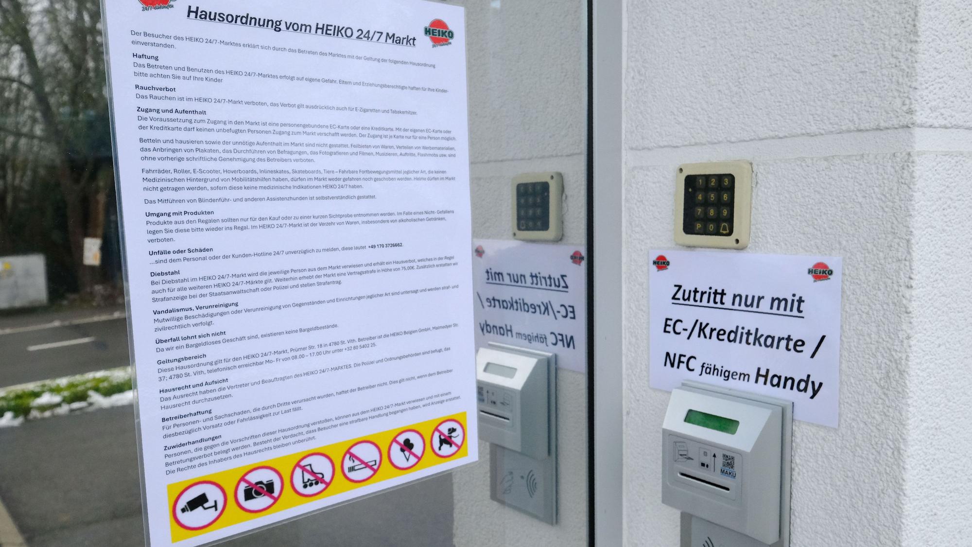 Aushang der Hausordnung und Einlass per EC-Karte am Eingang zum 24/7-Supermarkt.