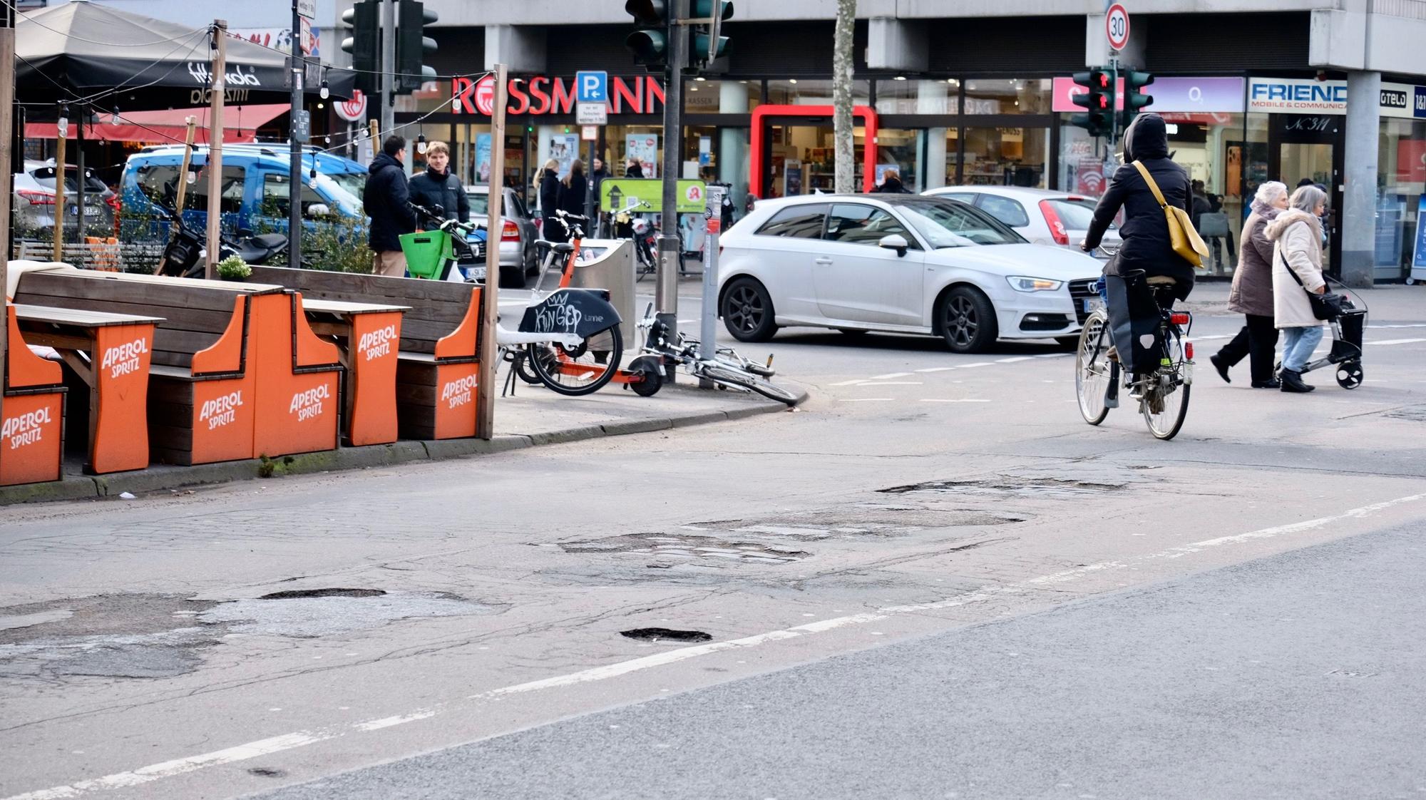 Blick auf eine Kreuzung und eine Asphaltdecke mit Löchern.