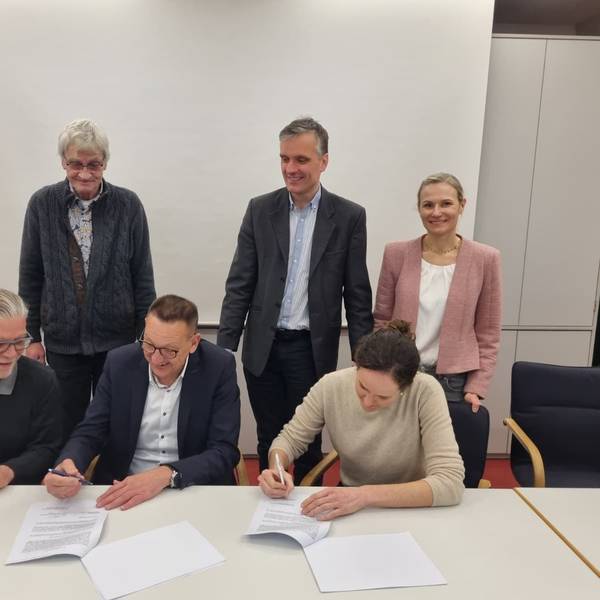 Die Stadt Burscheid und die Genossenschaft Bürgerenergie Bergisch Gladbach unterzeichnen den Vertrag für die Dachnutzung der Johannes-Löh-Gesamtschule.
