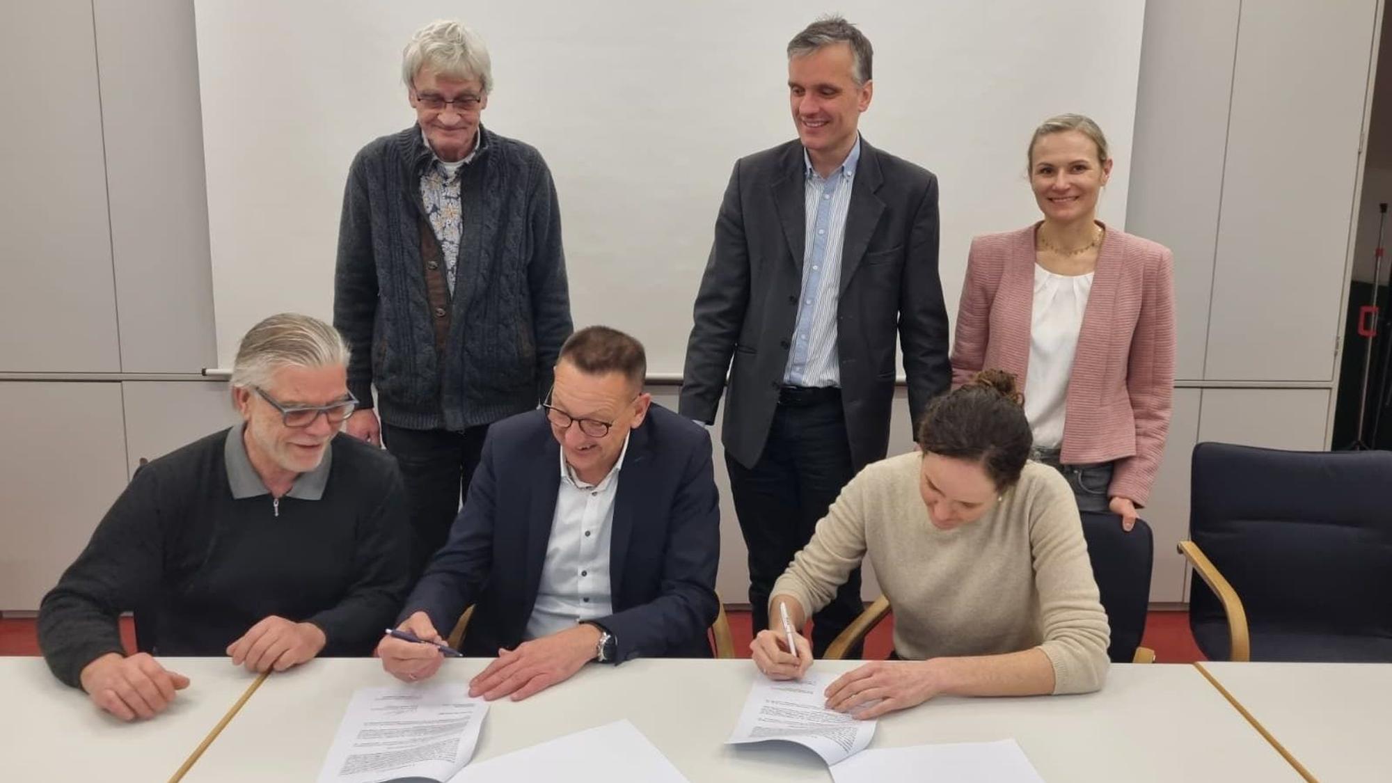 Die Stadt Burscheid und die Genossenschaft Bürgerenergie Bergisch Gladbach unterzeichnen den Vertrag für die Dachnutzung der Johannes-Löh-Gesamtschule.