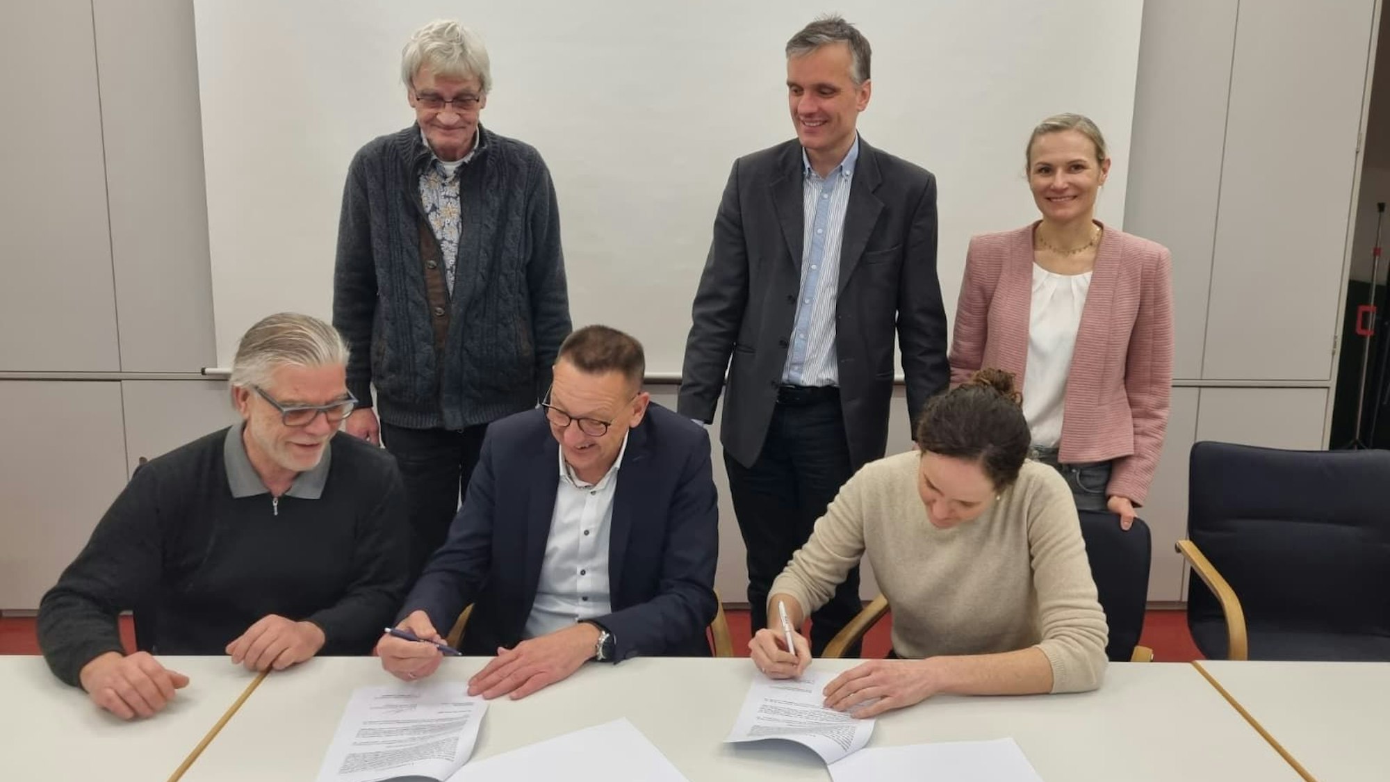 Die Stadt Burscheid und die Genossenschaft Bürgerenergie Bergisch Gladbach unterzeichnen den Vertrag für die Dachnutzung der Johannes-Löh-Gesamtschule.