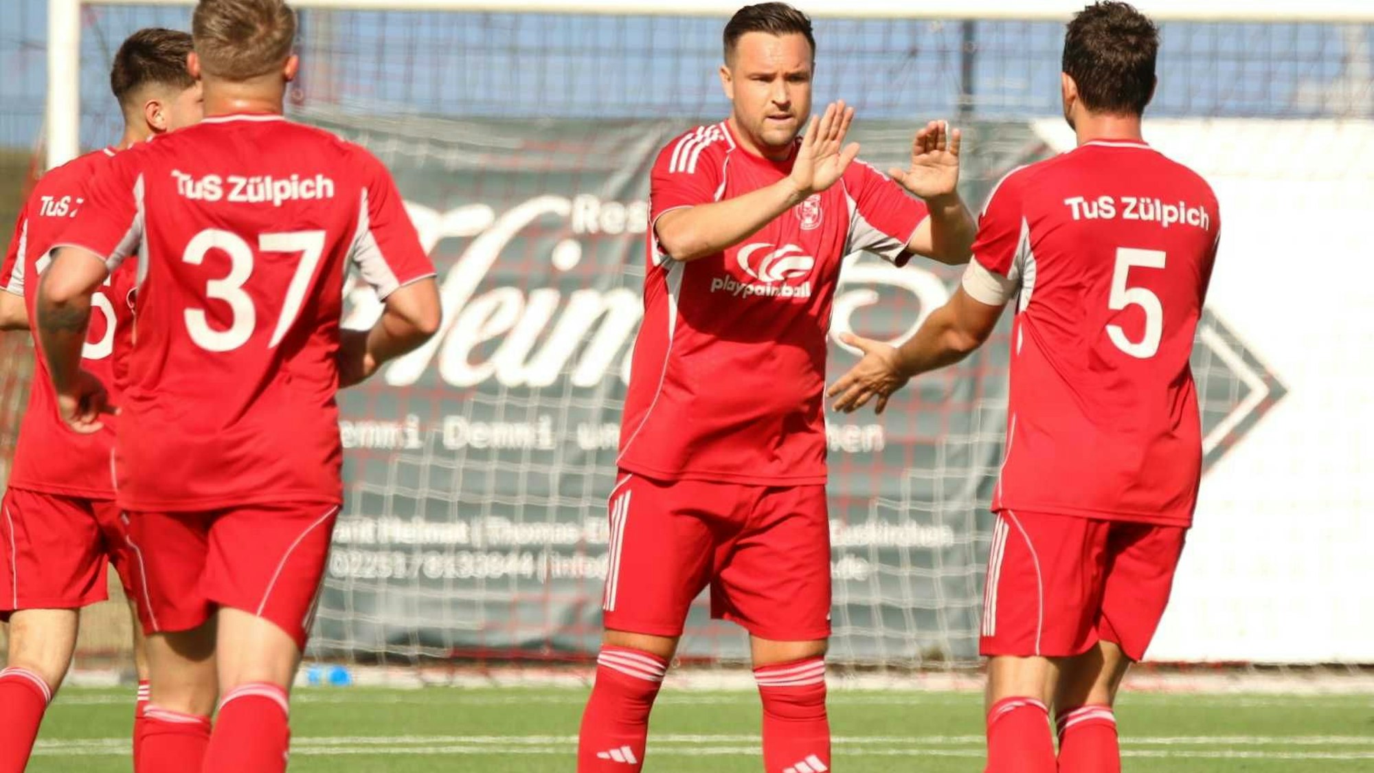 Das Bild zeigt Pascal Schiffer, der sich mit mehreren Spielern abklatscht.