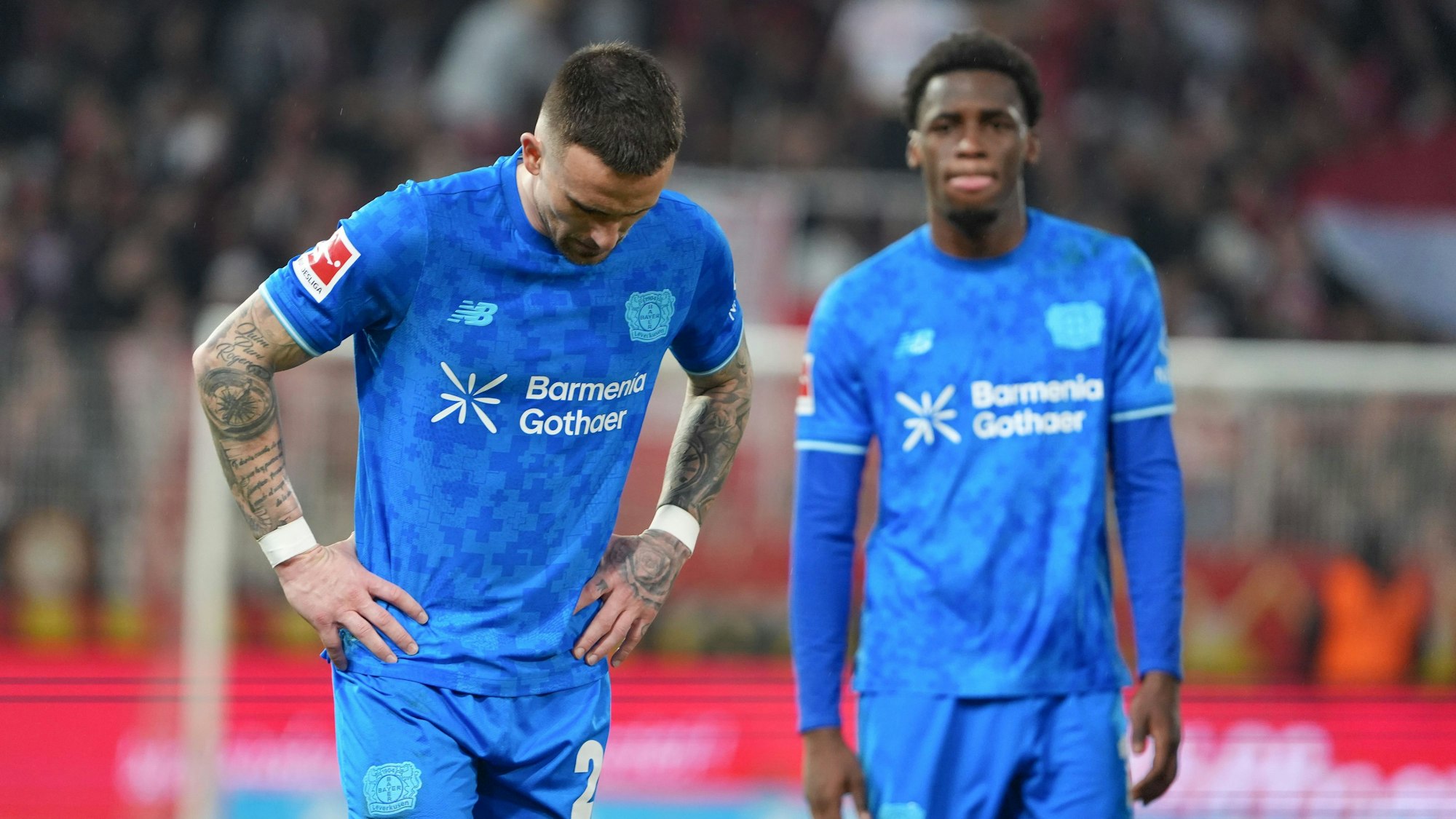 21.02.2026, Berlin: Fußball, Männer, Bundesliga, 23. Spieltag, 1. FC Union Berlin - Bayer Leverkusen, An der Alten Försterei: Álejandro Grimaldo (l) und Ernest Poku (Bayer Leverkusen) zeigen sich nach dem Schlusspfiff enttäuscht. Foto: Soeren Stache/dpa - WICHTIGER HINWEIS: Gemäß den Vorgaben der DFL Deutsche Fußball Liga bzw. des DFB Deutscher Fußball-Bund ist es untersagt, in dem Stadion und/oder vom Spiel angefertigte Fotoaufnahmen in Form von Sequenzbildern und/oder videoähnlichen Fotostrecken zu verwerten bzw. verwerten zu lassen. +++ dpa-Bildfunk +++