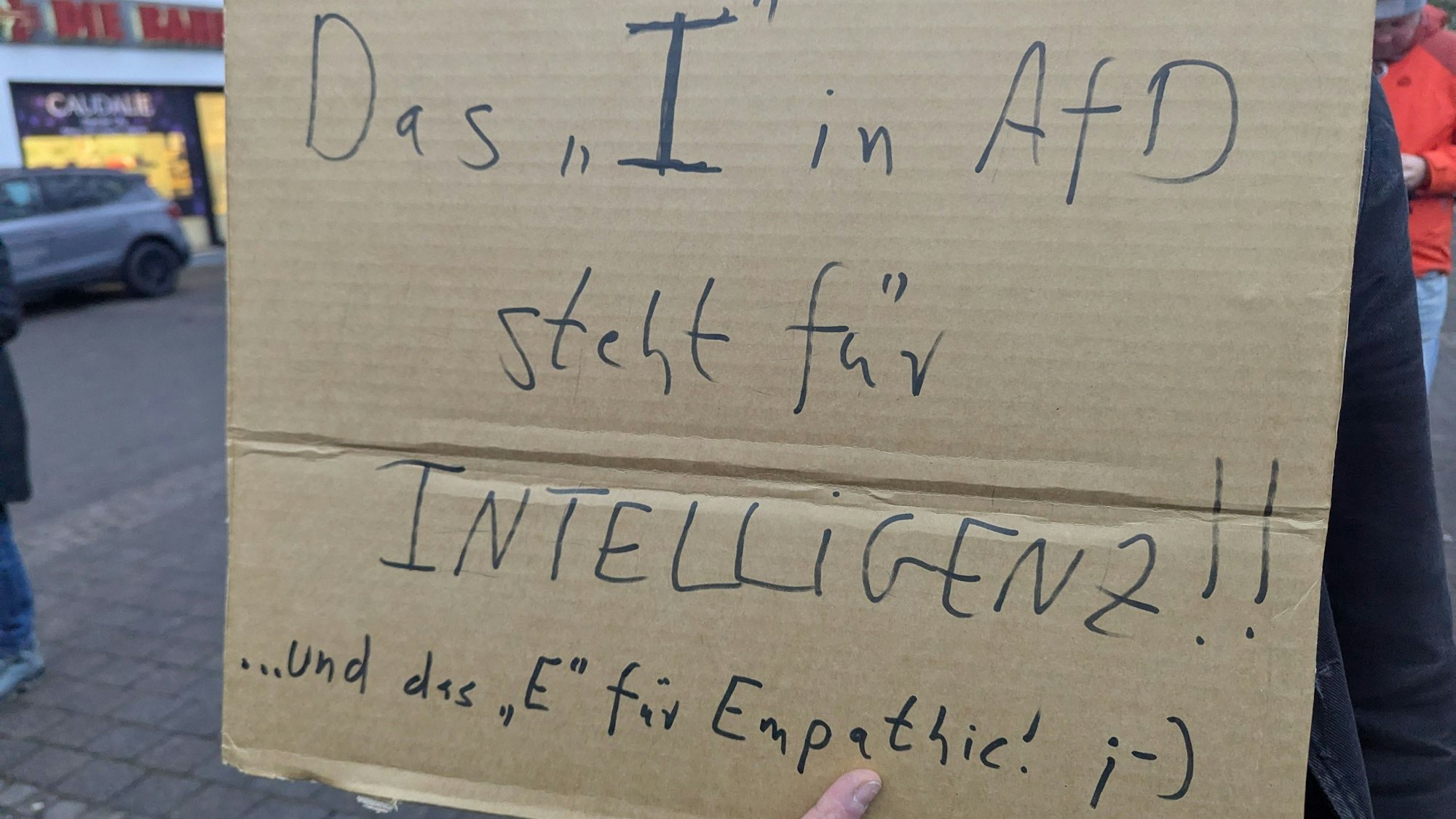 Auf einem Pappschild steht: „Das ‚i‘ in AfD steht für Intelligenz“.