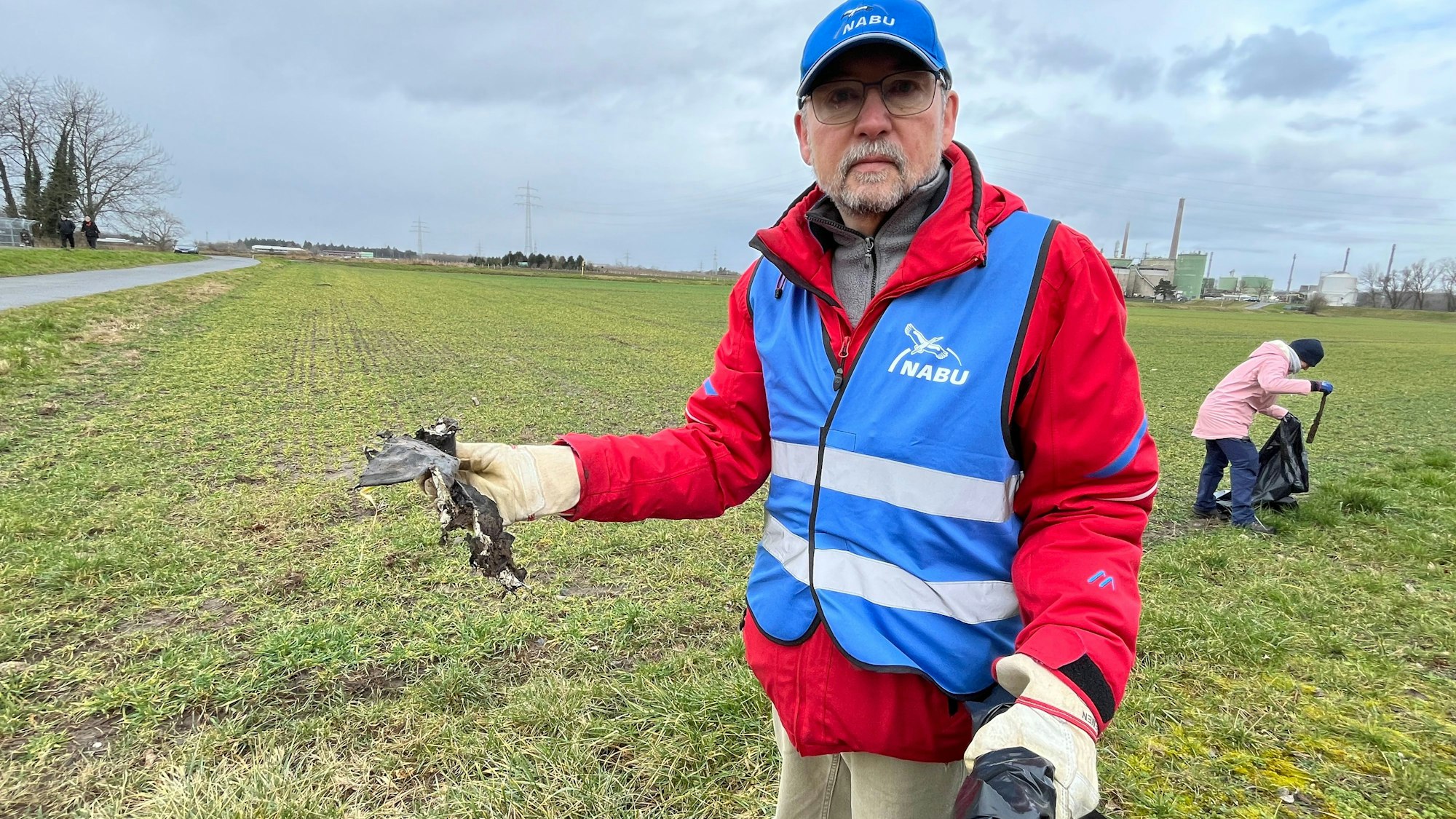 Zu sehen ist ein Mann beim Müllsammeln.